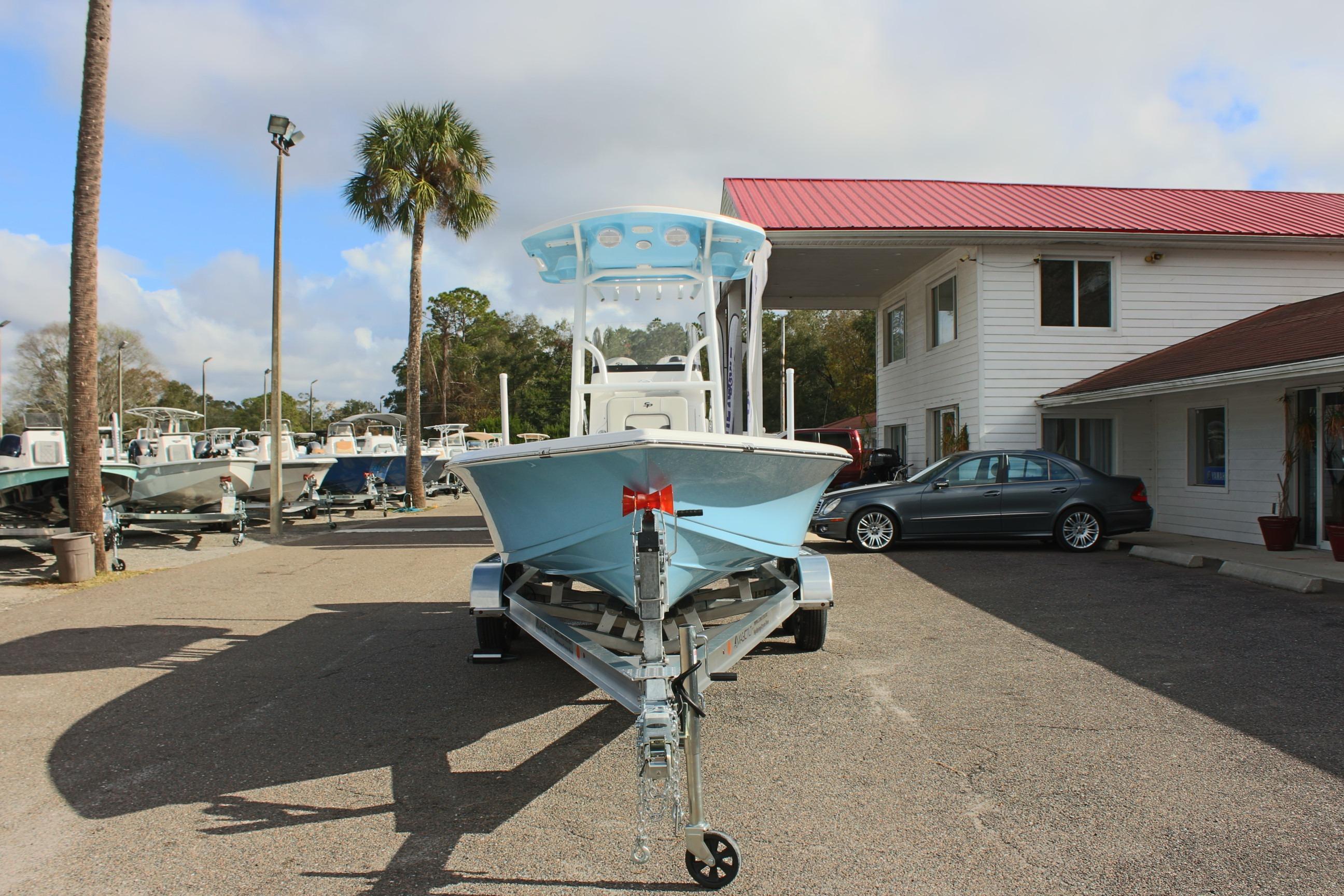 2025 Sea Pro 230 Bay boat on trailer at dealership, sunny day.