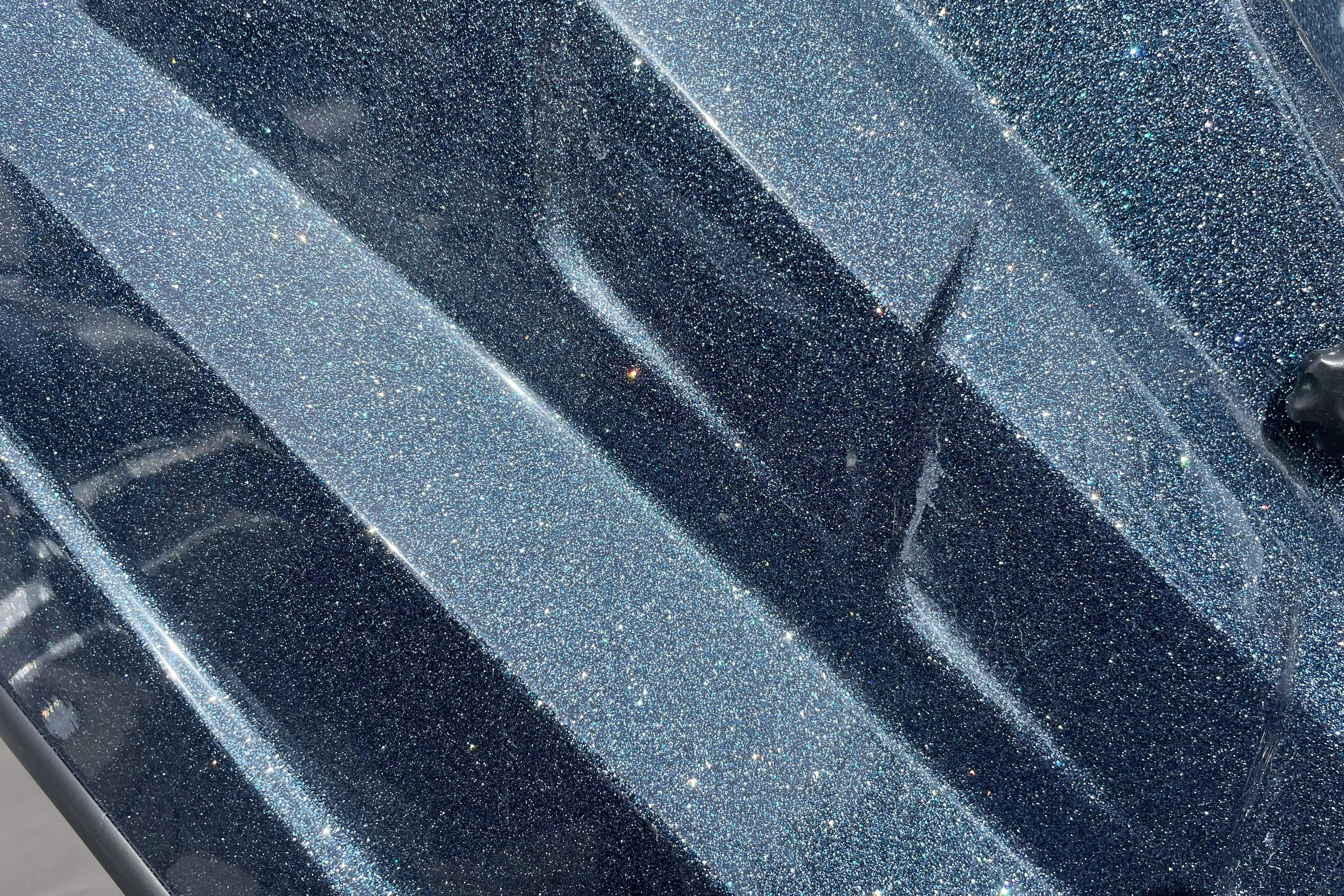 Metallic blue surface of 2026 Nitro Z21 XL boat, showcasing glittery finish.