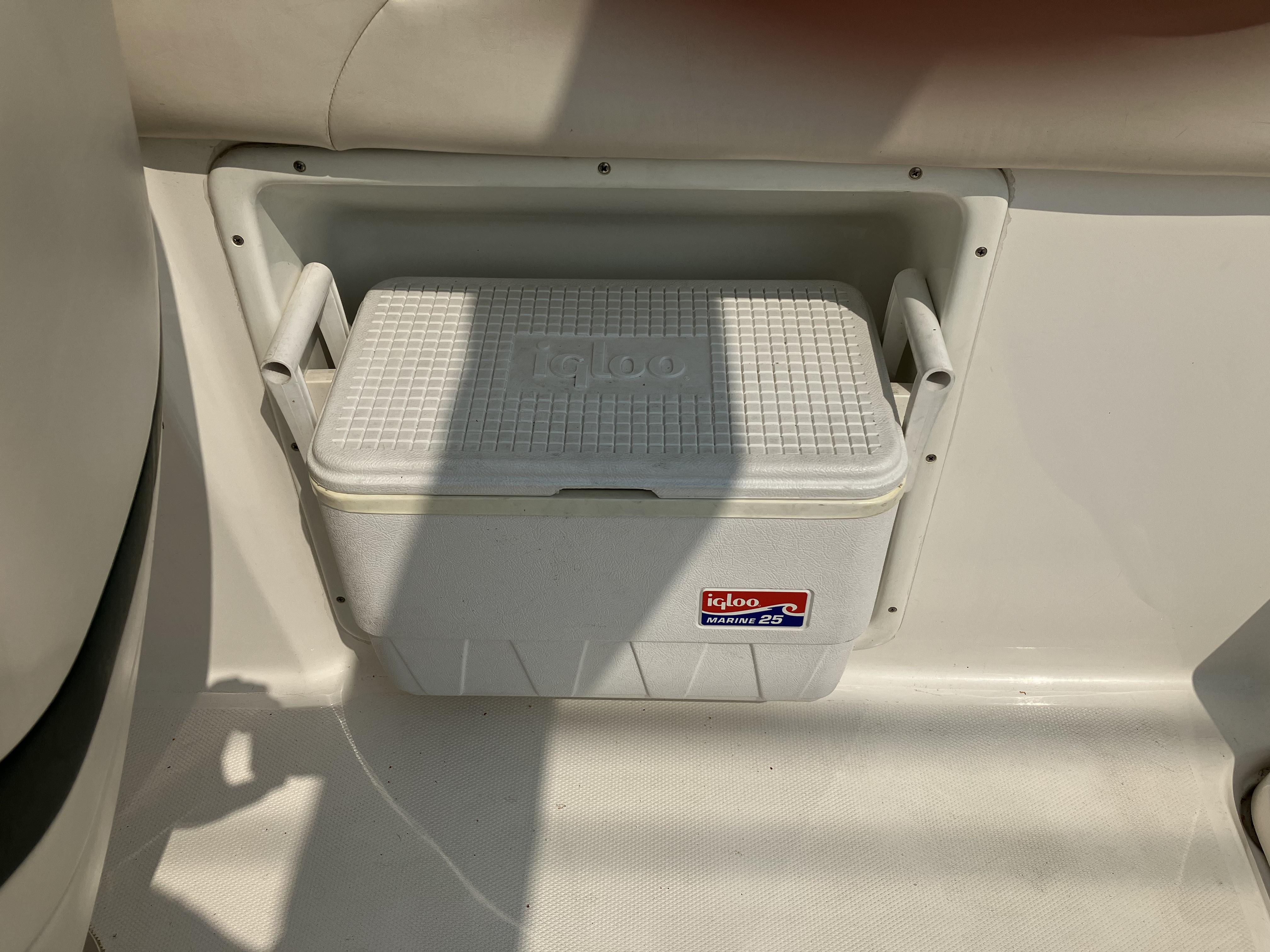 An Igloo cooler is fitted into a compartment on a boat.