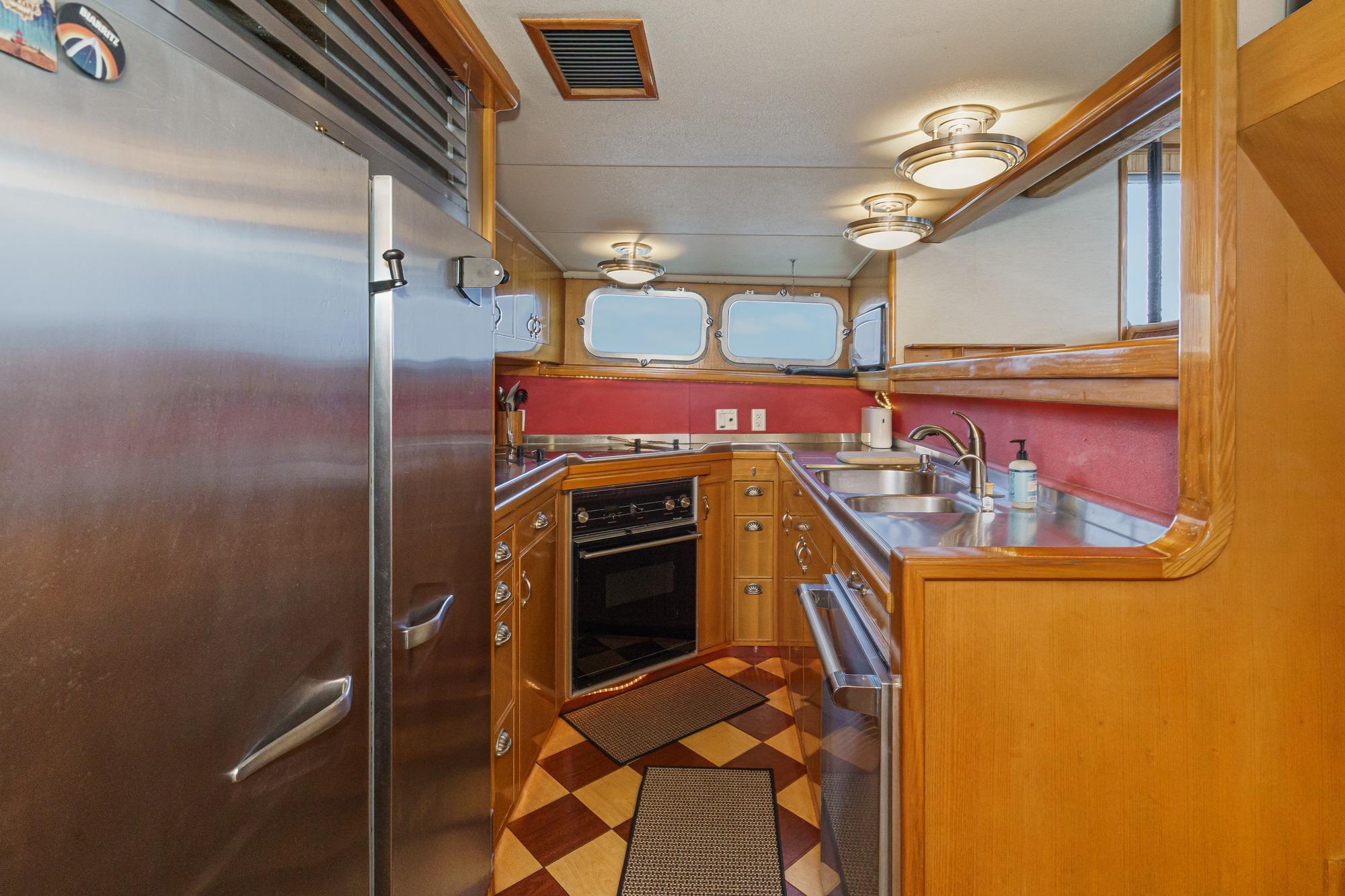 1990 Seaton Long Range Cruiser kitchen with stainless steel appliances and wooden cabinetry.