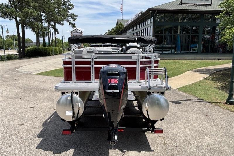 2026 Sun Tracker SportFish 20 DLX pontoon boat with Mercury 115 outboard motor, parked outdoors.
