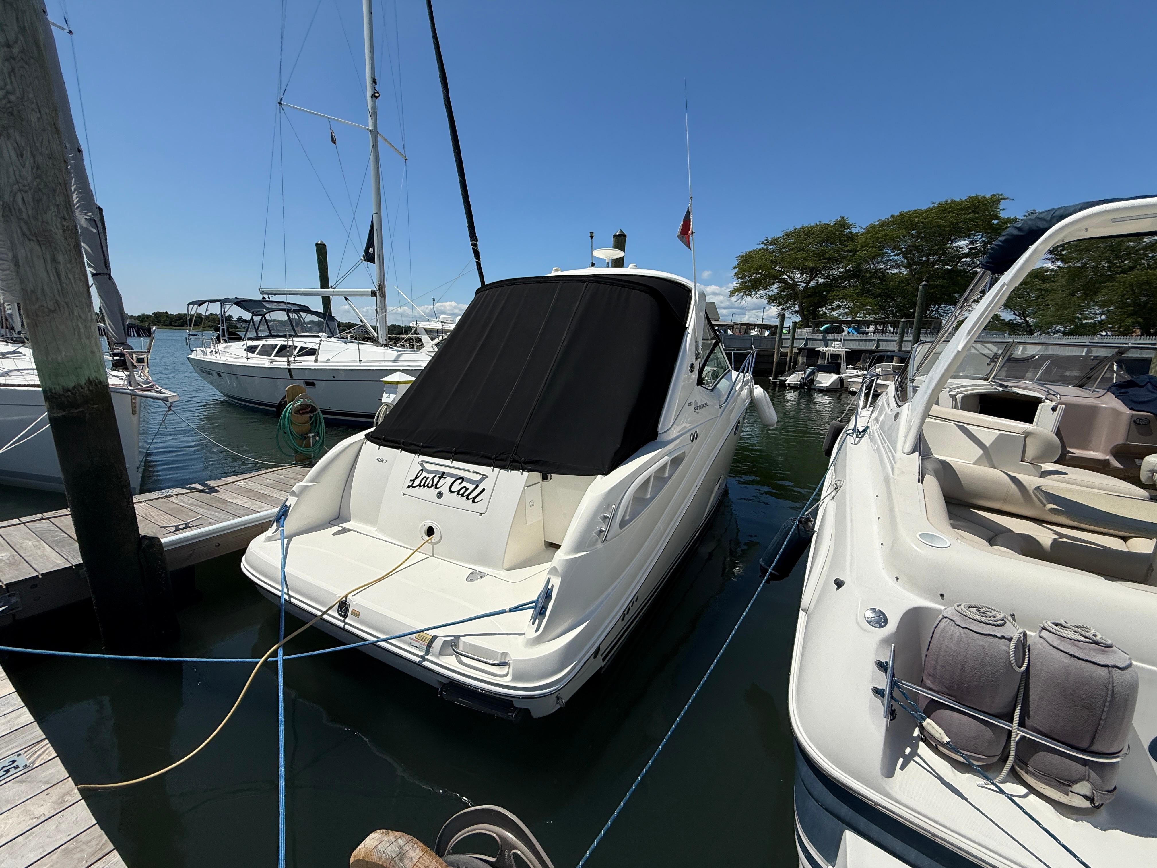 2006 Sea Ray 290 Sundancer docked at marina, sunny day, surrounded by other boats.