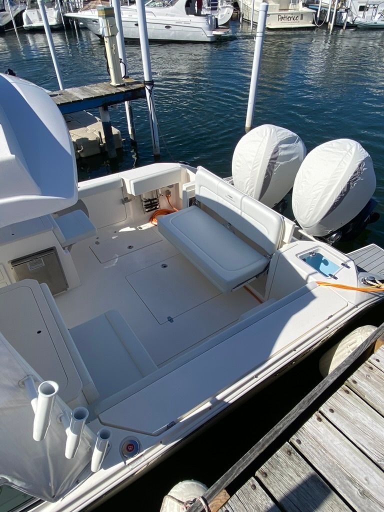 2023 Cobia 330 boat docked with dual engines.