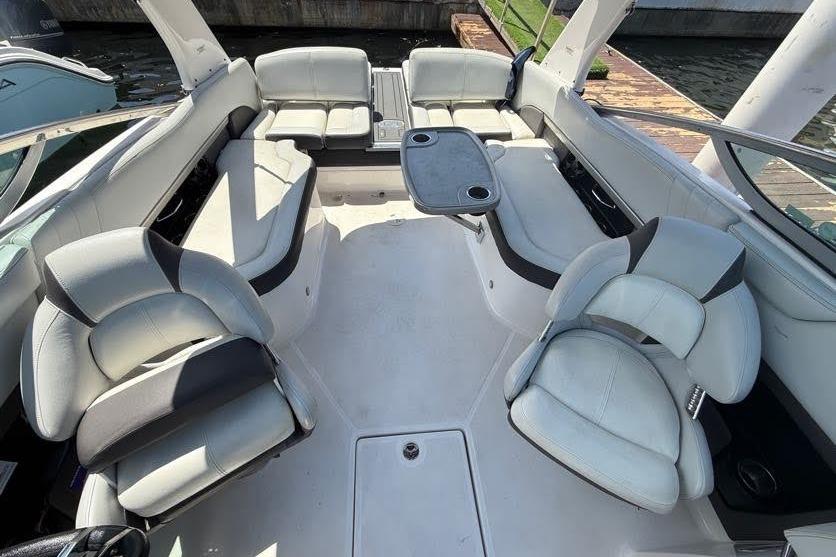 2014 Regal 2500 Bowrider interior with white seating and table, docked by the water.