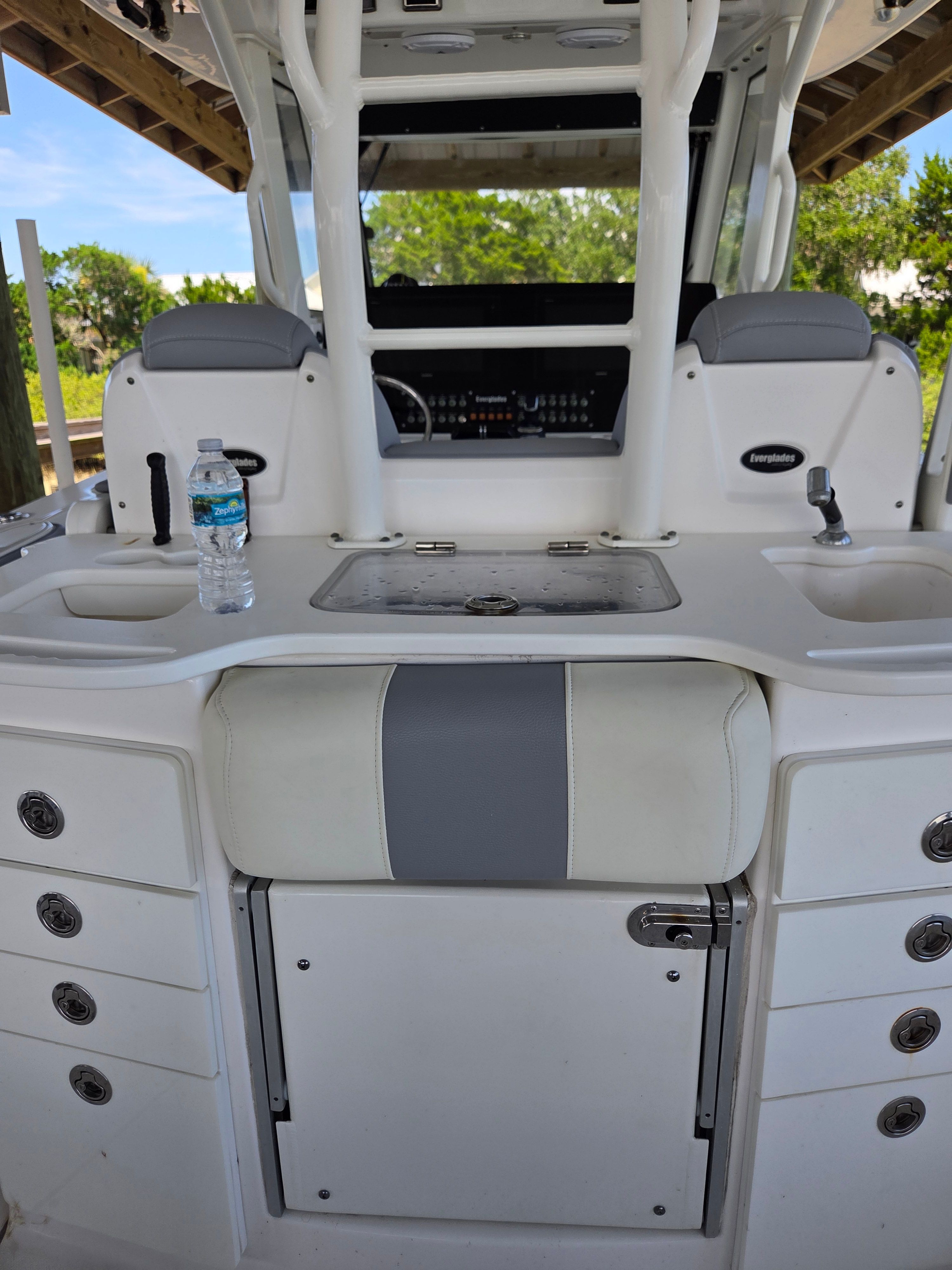 The image shows the cockpit of a 2017 Everglades 355 Center Console boat. There's a helm console with instruments and a water bottle on the counter.