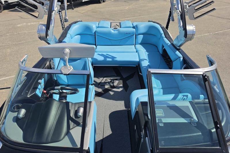 2017 MasterCraft X23 boat interior with blue seating and modern dashboard.