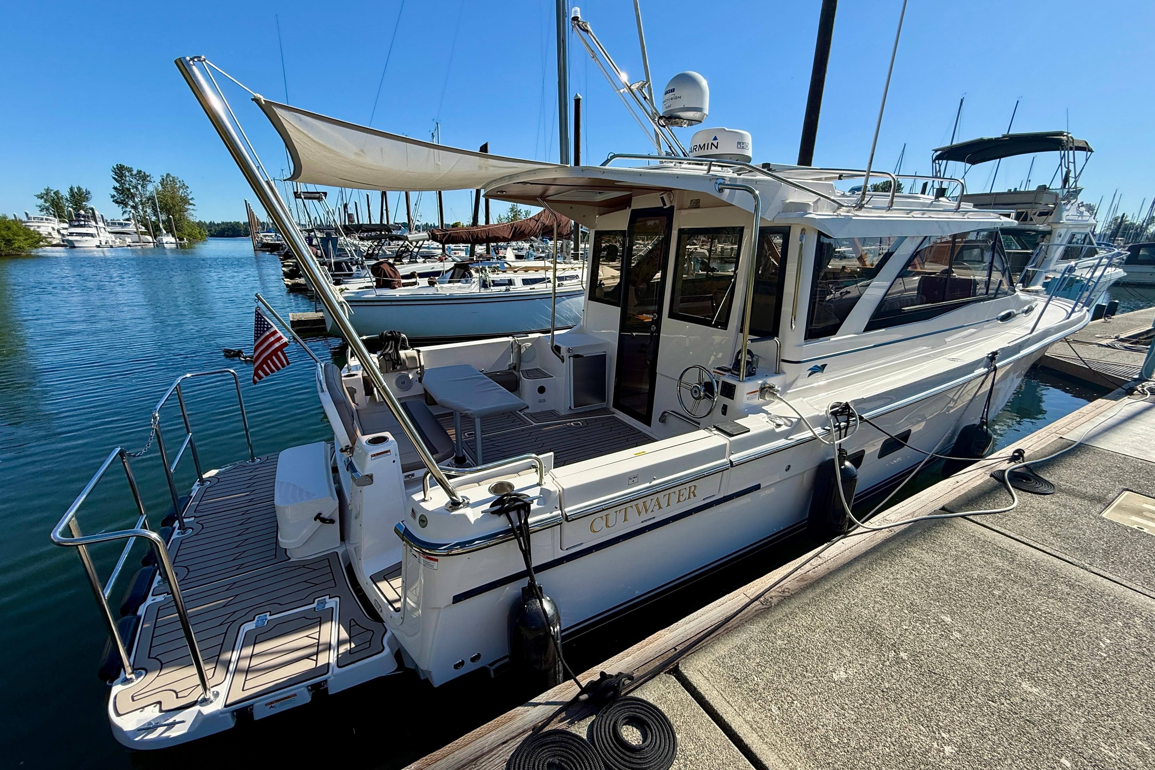 2023 Cutwater C-30 Sedan docked at marina, featuring sleek design and spacious deck.