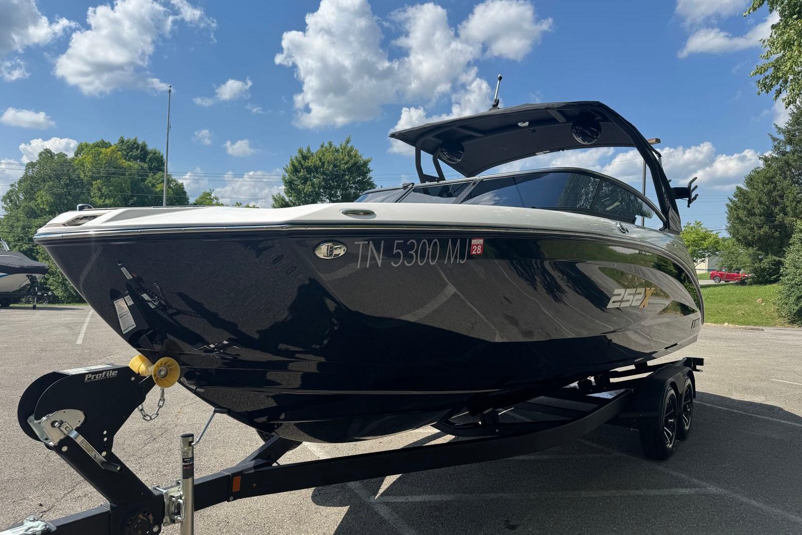2023 Yamaha Boats 252XE on trailer under blue sky, showcasing sleek design.