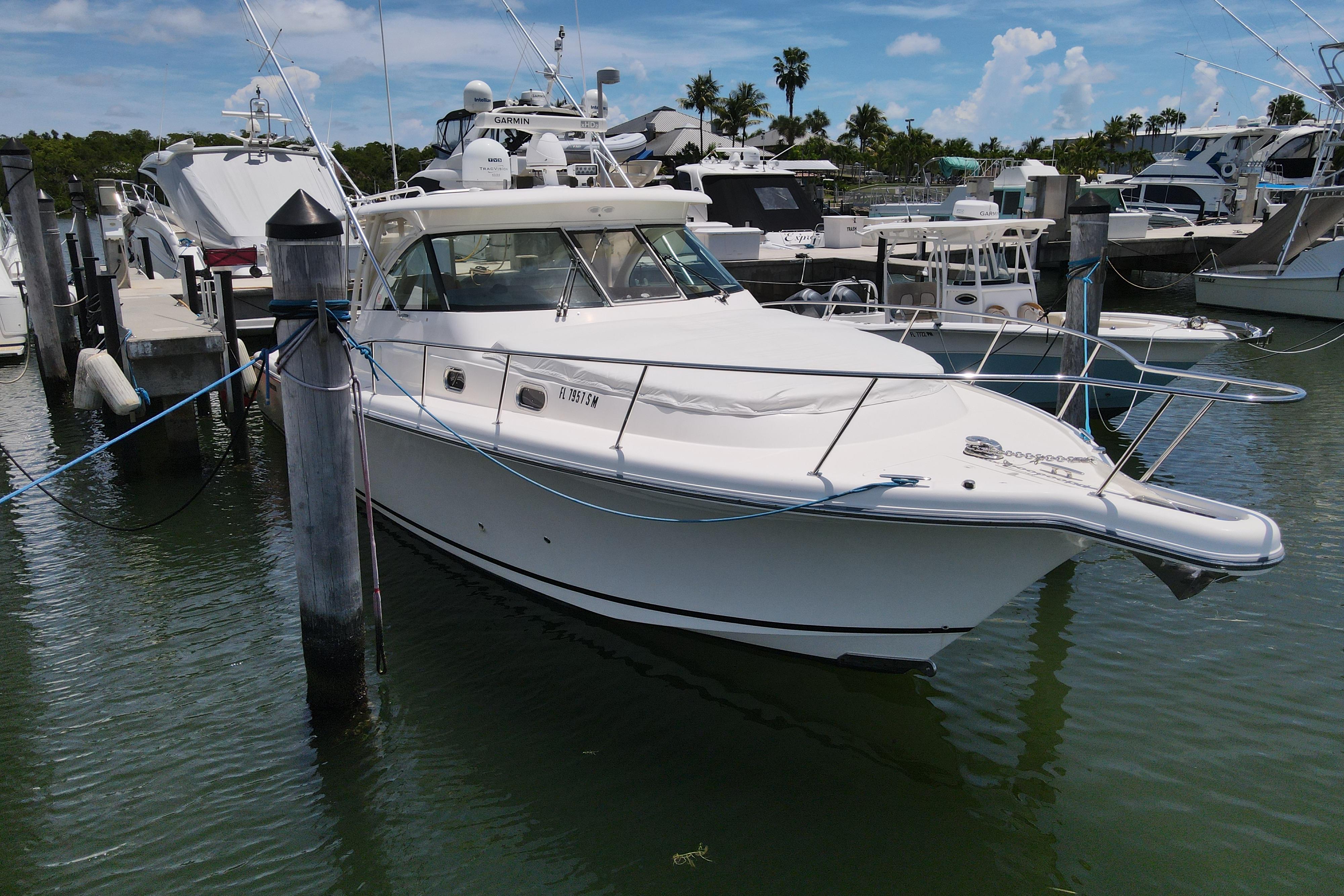 2010 Pursuit OS 375 Offshore boat docked at marina, surrounded by other vessels.