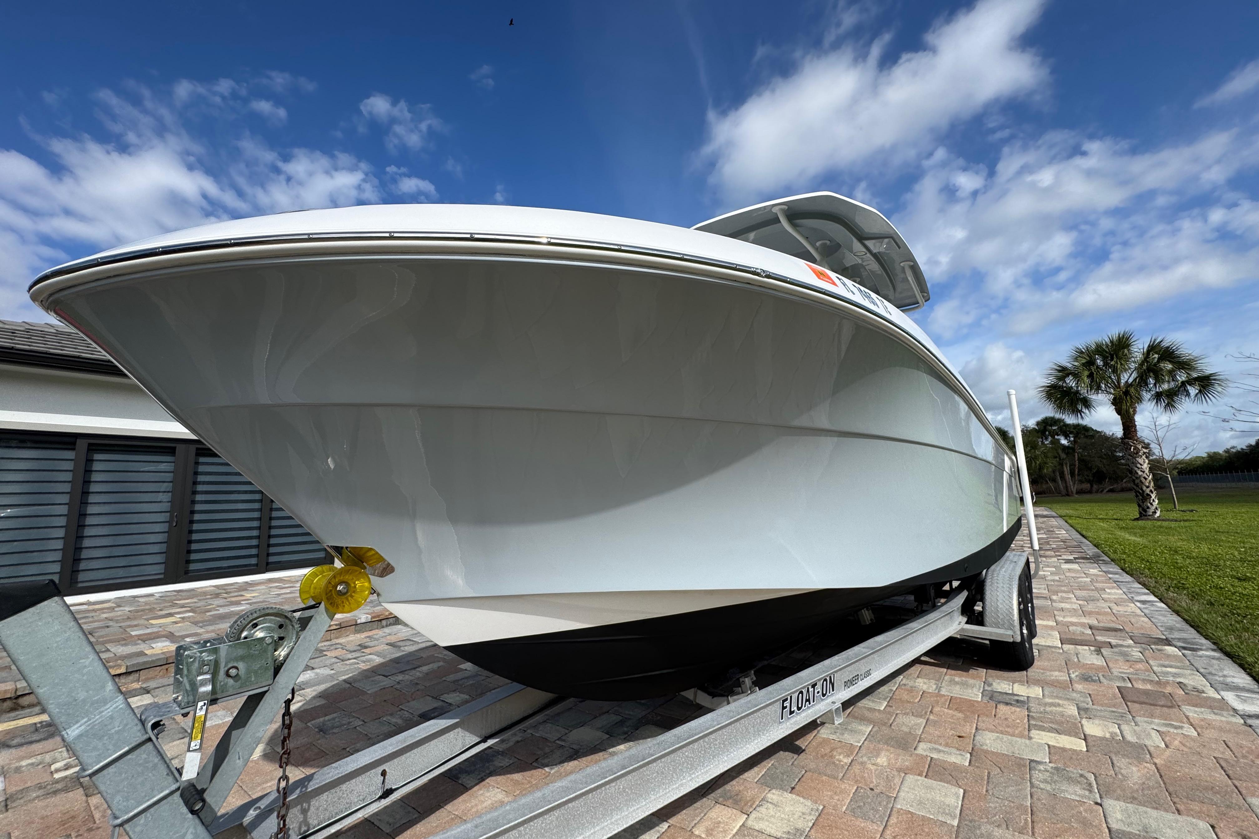 2022 Aquasport 2500 Center Console boat on trailer, parked on brick driveway.