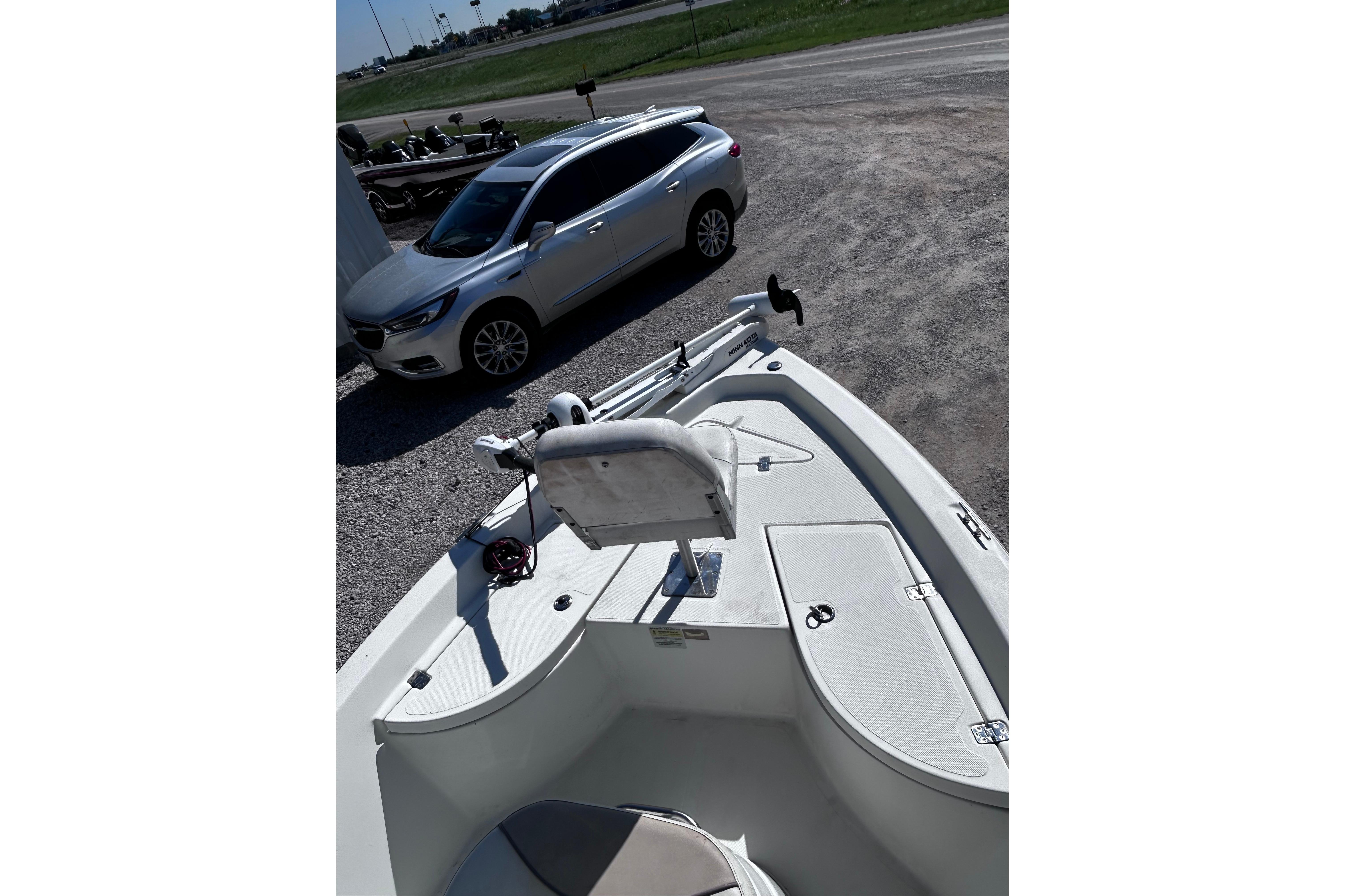 2016 NauticStar 1810 NauticBay boat parked beside a silver car.