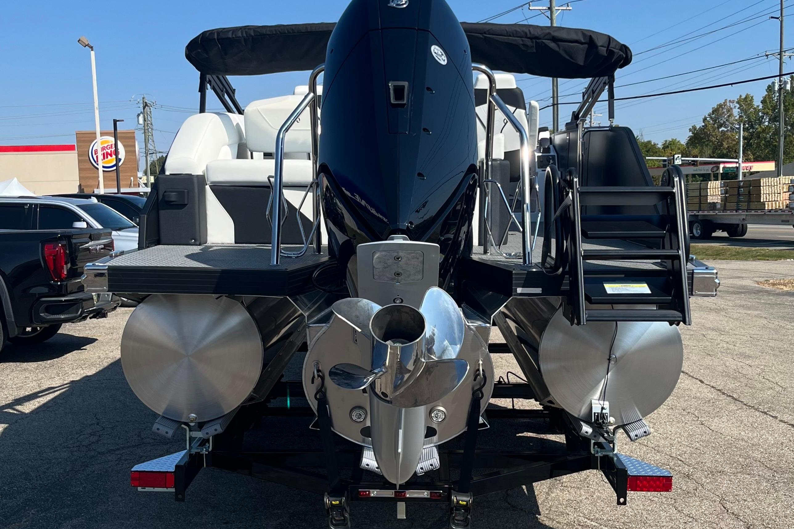 2026 Evotti 725CS pontoon boat with powerful outboard motor, parked outdoors.