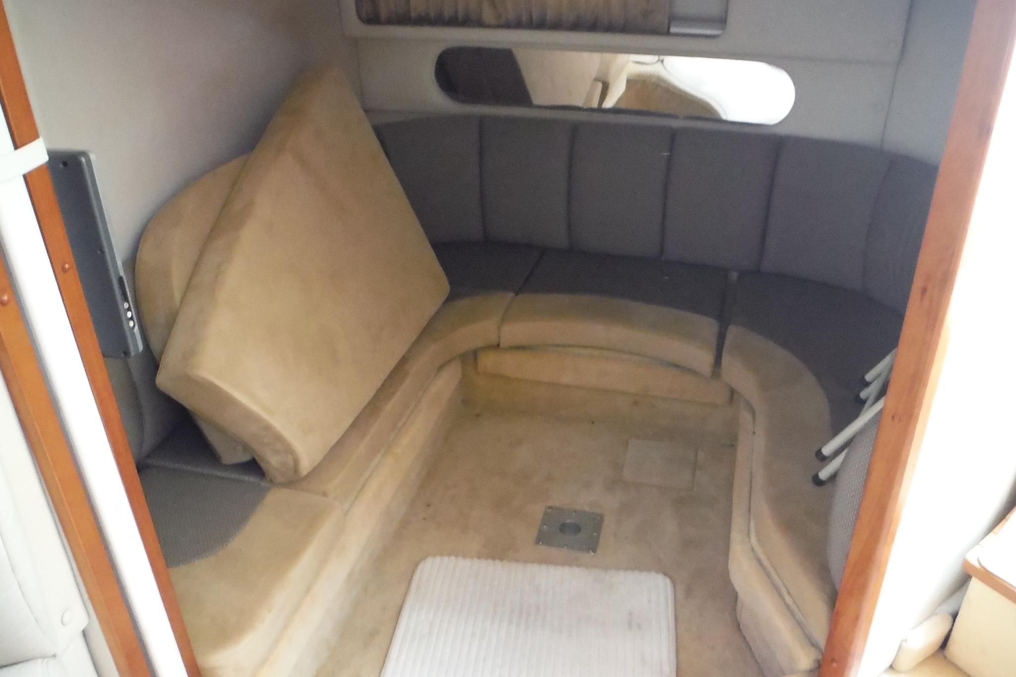 2005 Chaparral Signature 350 cabin interior with curved seating and beige cushions.