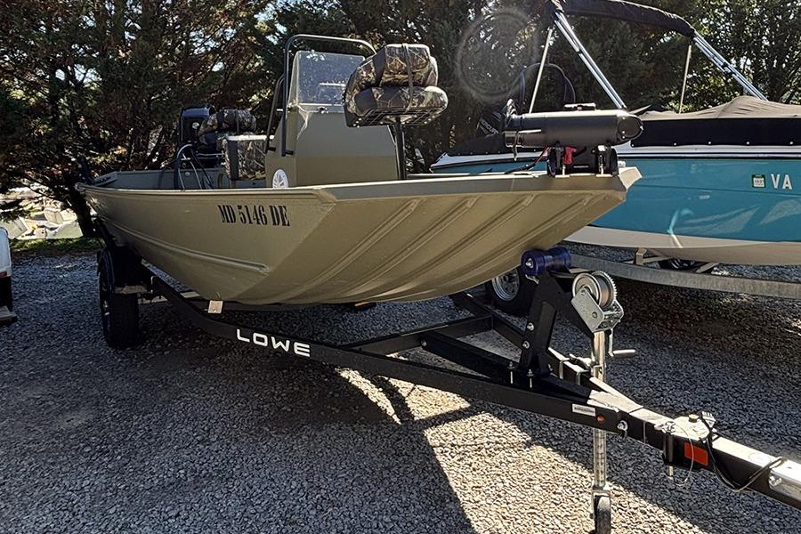 2022 Lowe Roughneck 1660 boat on trailer, parked outdoors, side view.