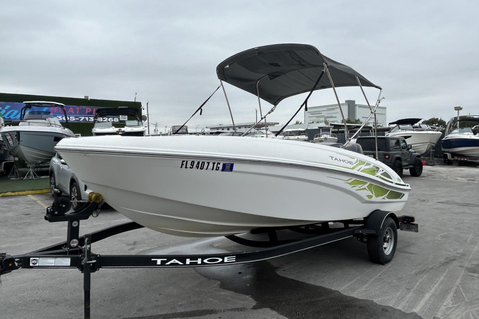 2022 Tahoe T18 boat on trailer with canopy, parked in a marina.