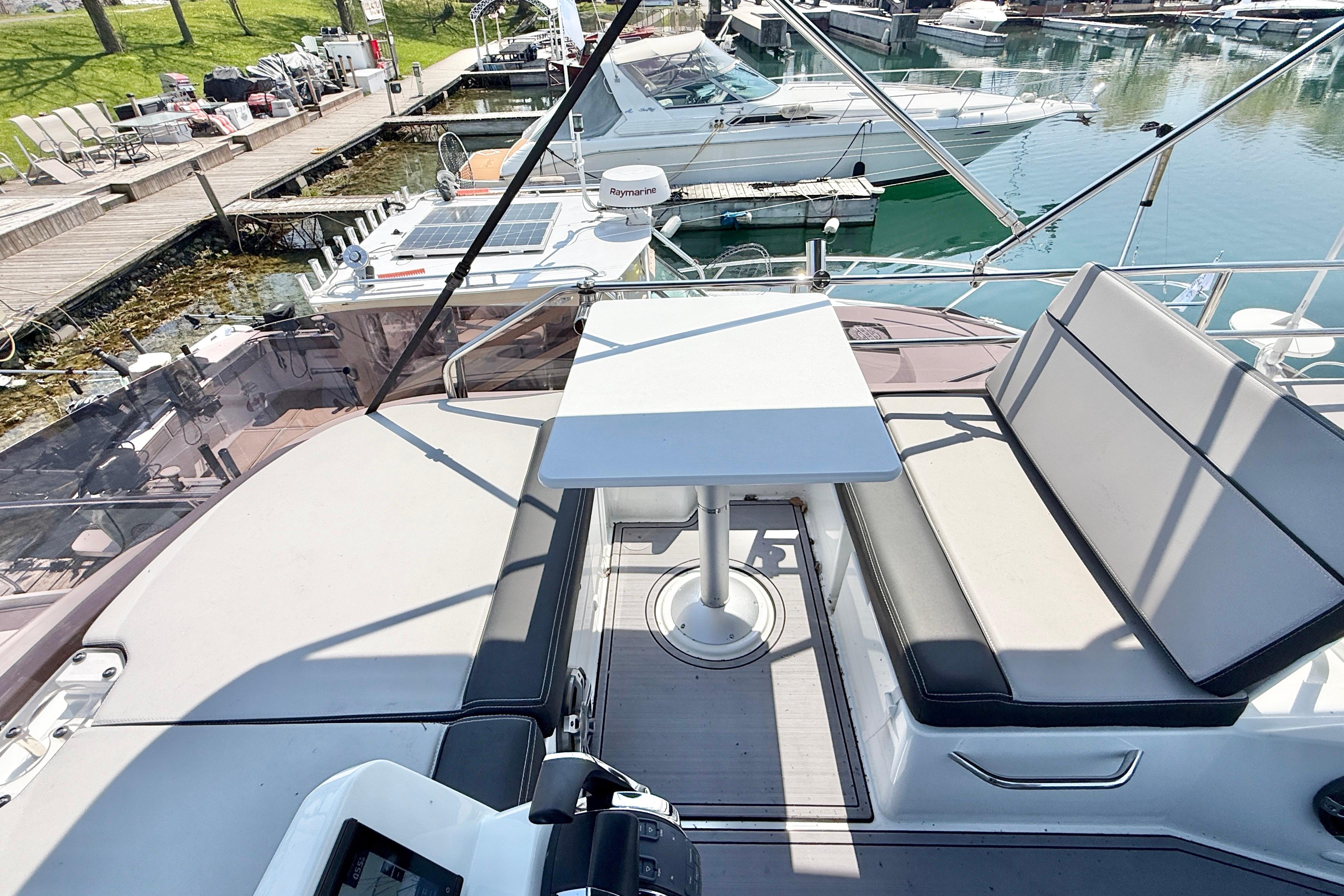 Flybridge seating area on 2022 Jeanneau NC 1095 Fly, docked at marina.