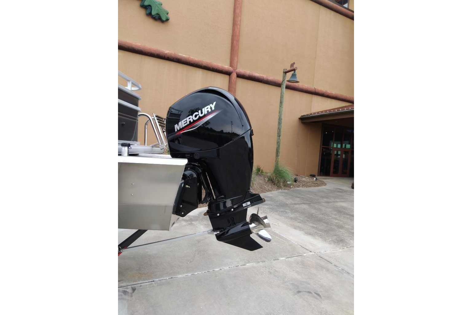 2025 Sun Tracker Fishin' Barge 22 XP3 with Mercury outboard motor displayed outdoors.