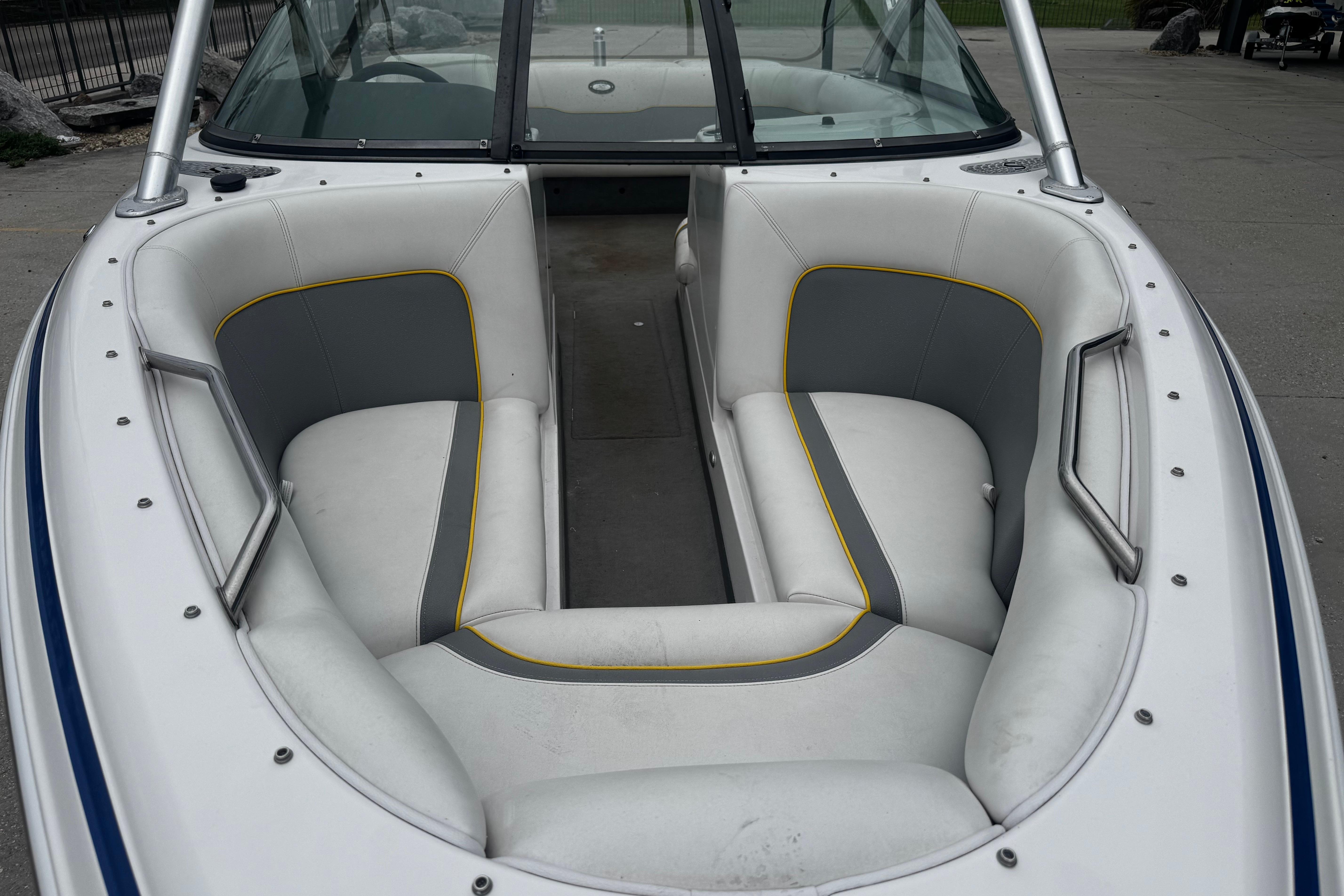 2006 Supra Launch 22 SSV boat interior with white and gray seating, yellow accents.