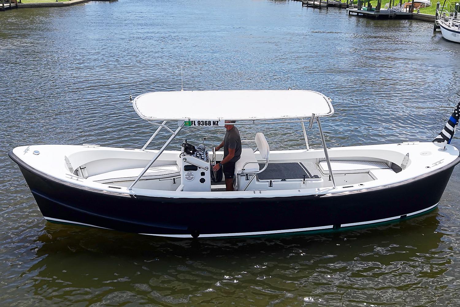 A 1969 custom boat with a canopy, cruising on a calm waterway.