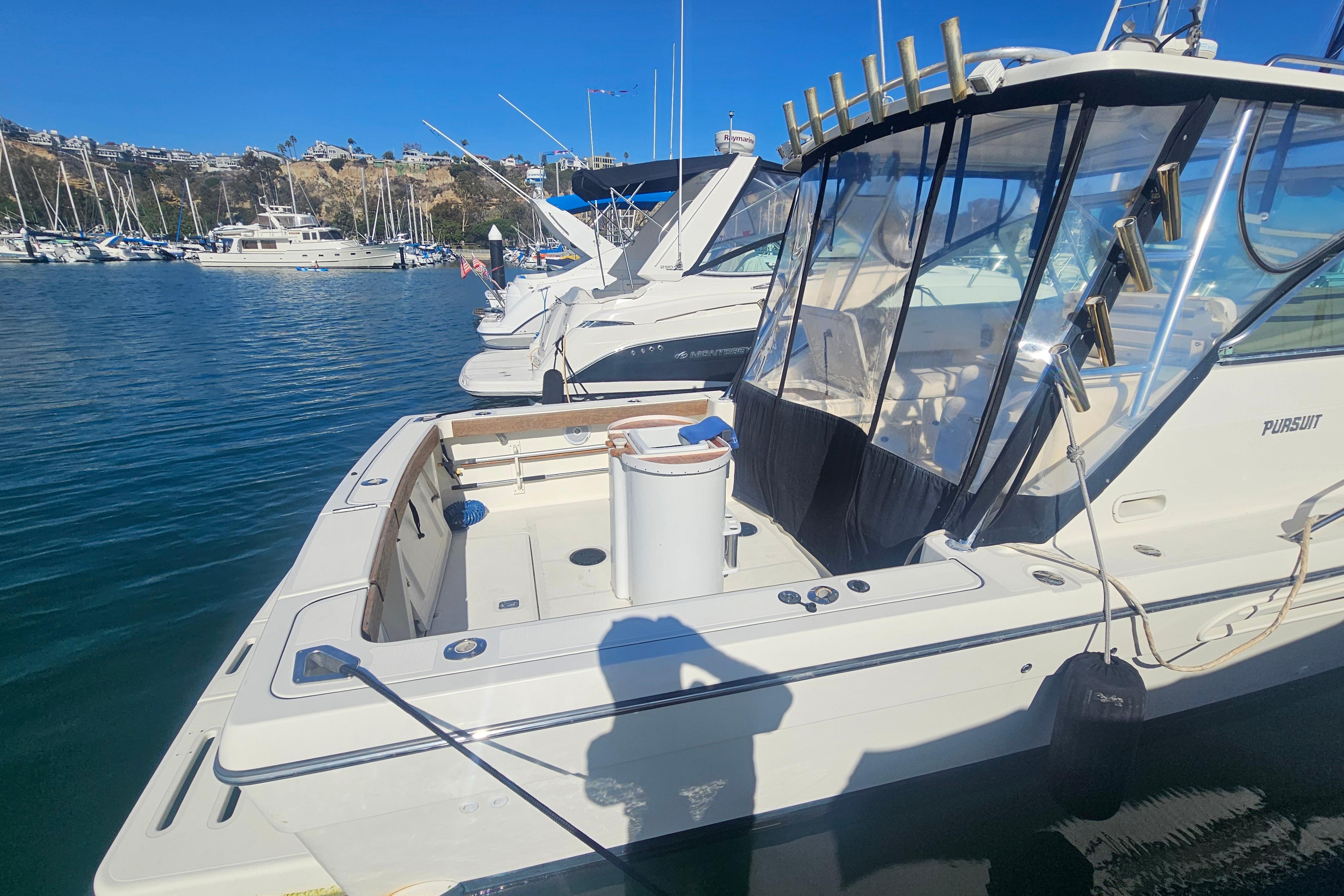 2001 Pursuit 3000 Express boat docked in a marina under clear blue skies.