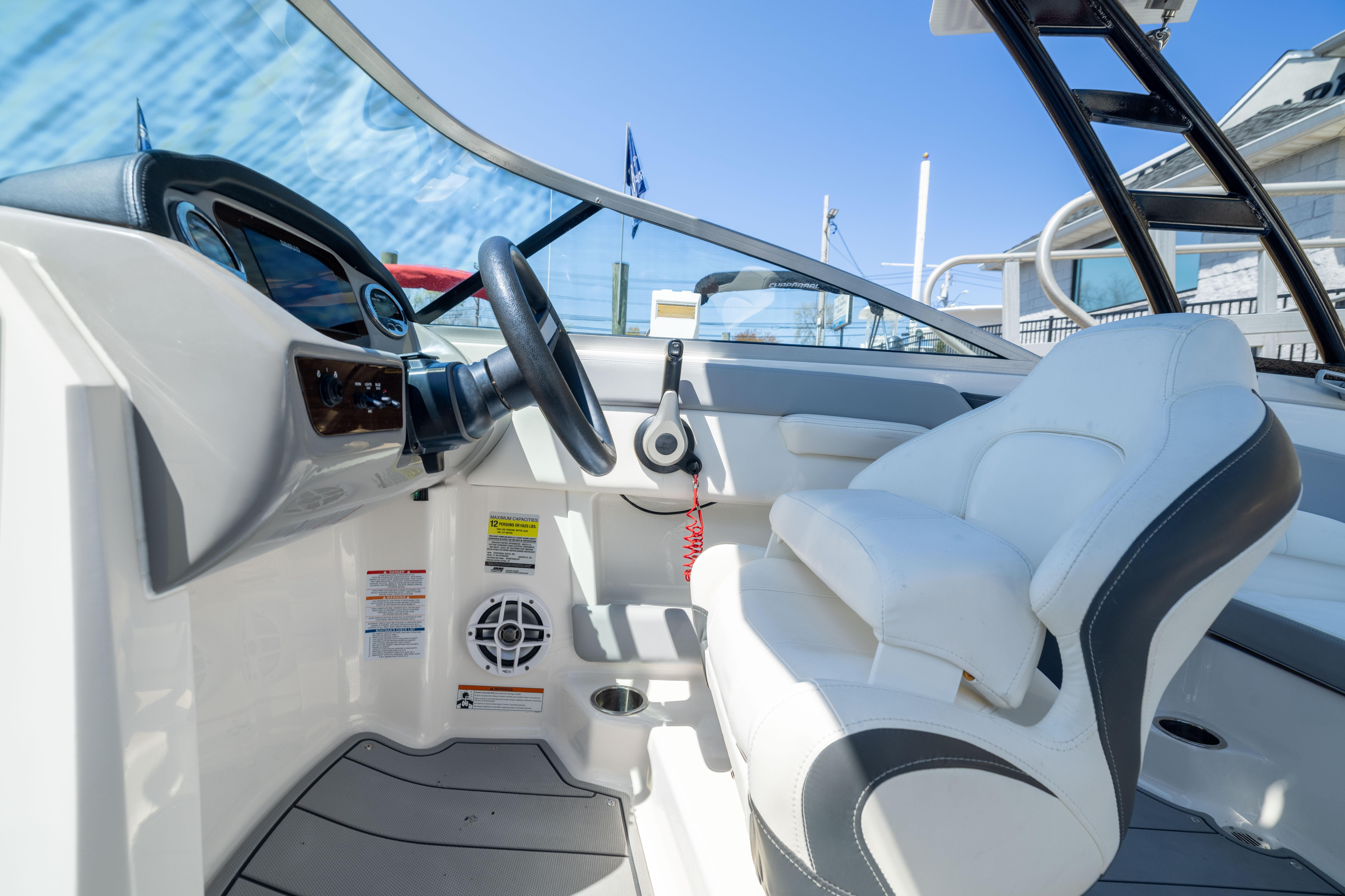 2022 Chaparral 21 SSi OB boat interior with steering wheel and white seating.