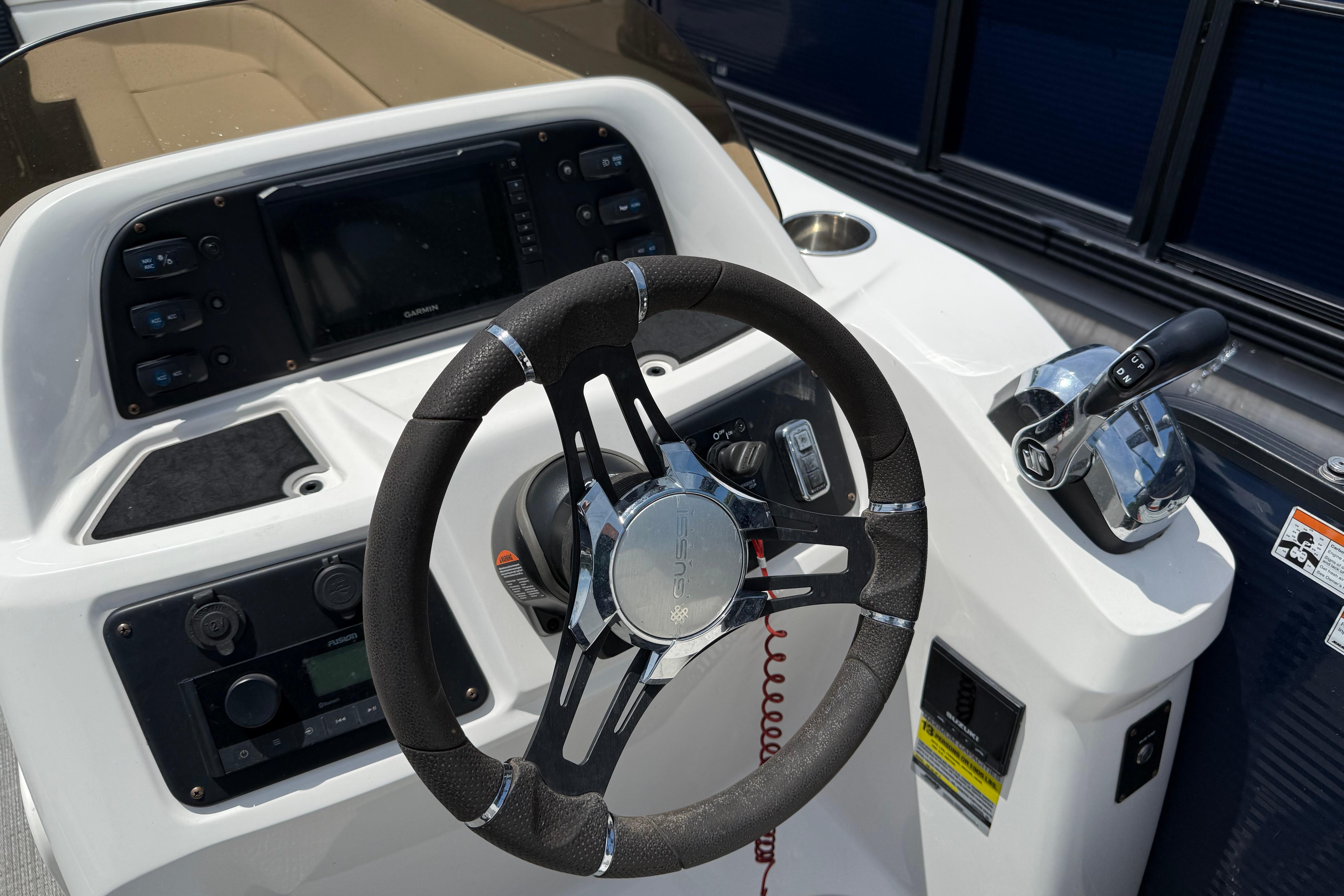 Steering console of 2022 Manitou Aurora LE boat with modern controls and dashboard.