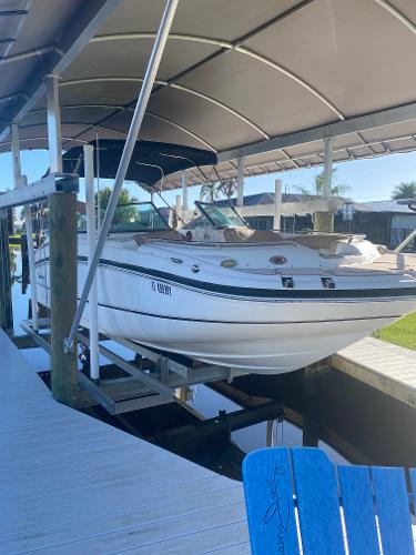 2015 Hurricane SunDeck 2400 OB boat docked under canopy.