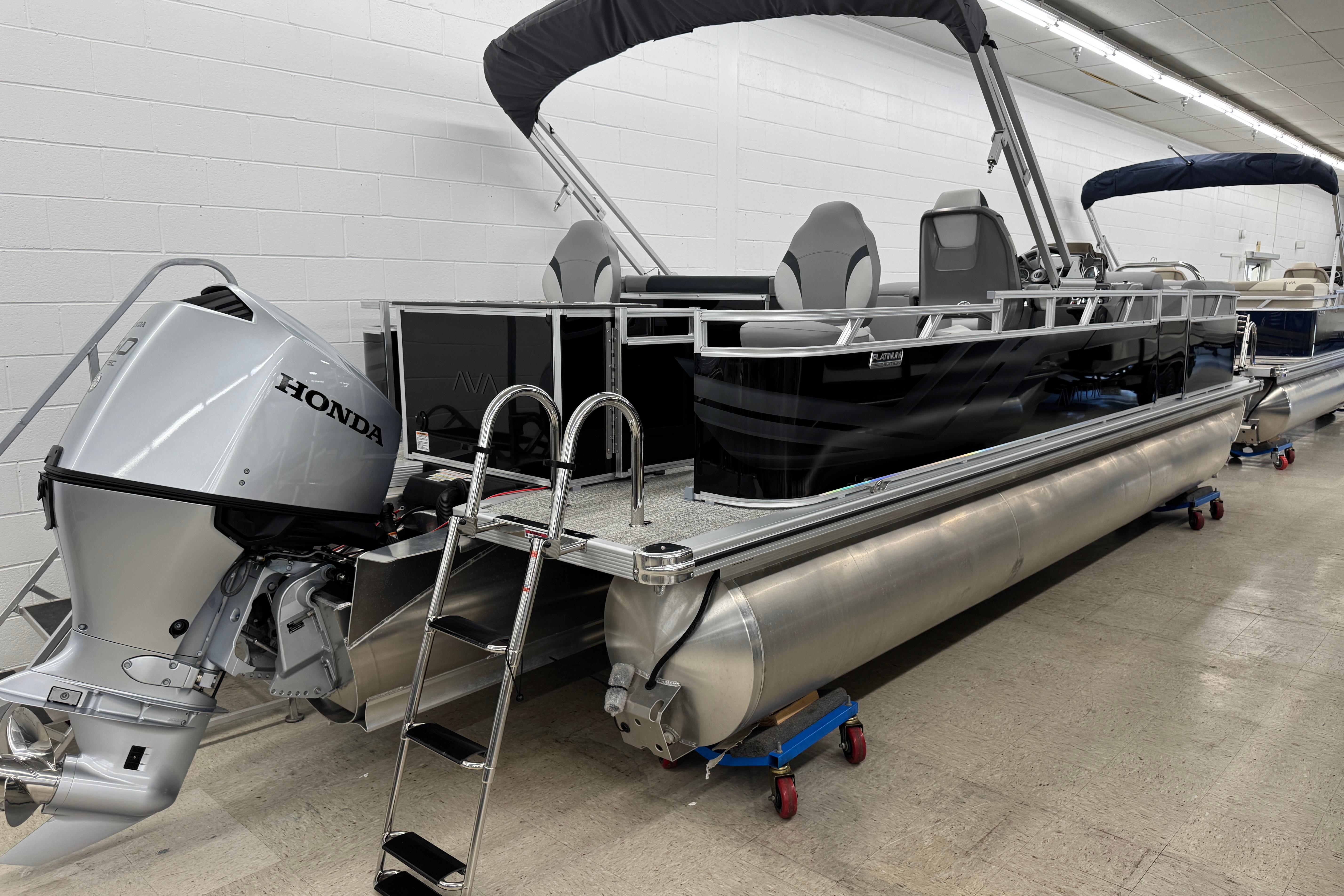 2026 Avalon Ventue 85 RF pontoon boat with Honda outboard motor in showroom.