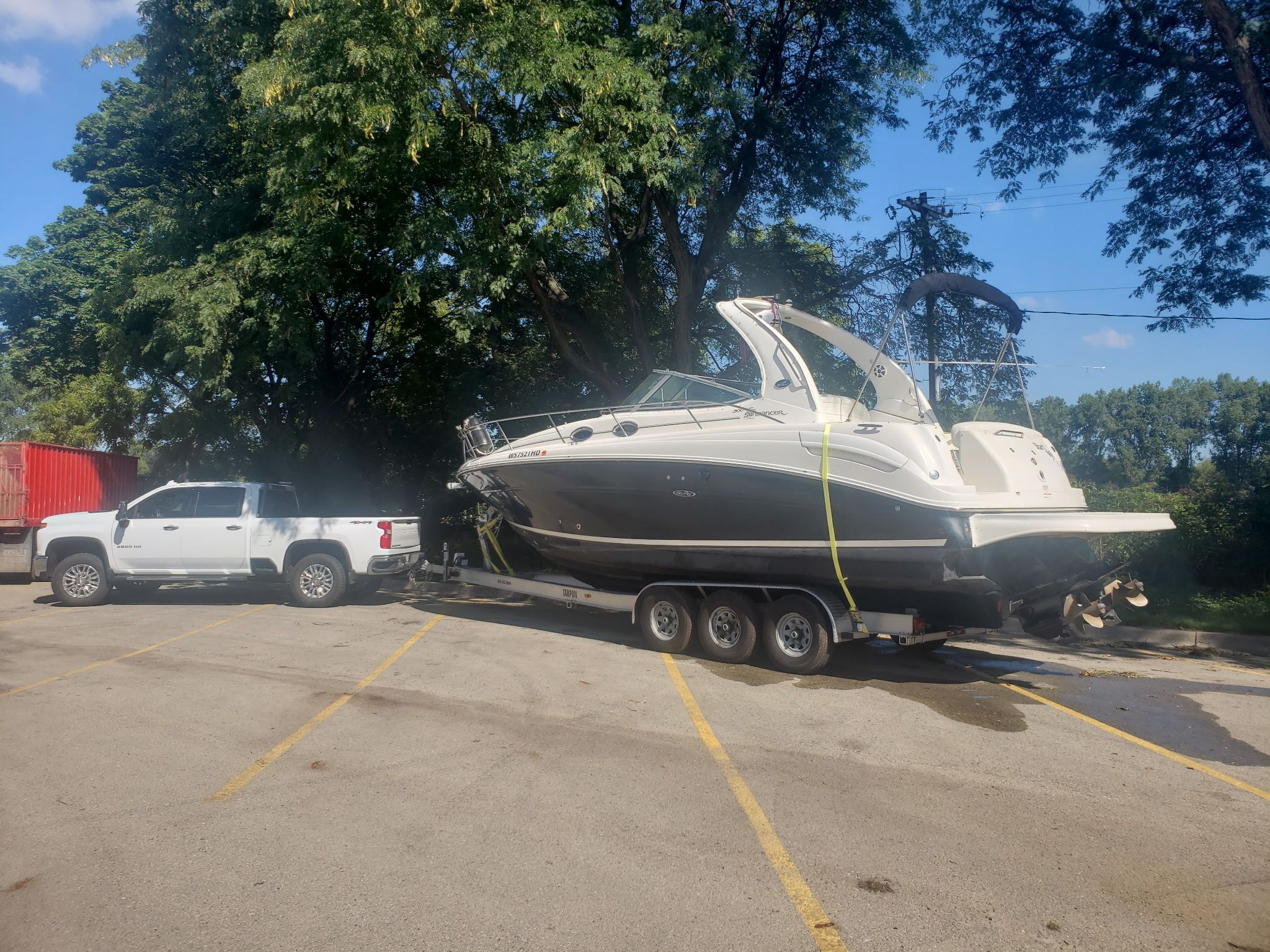 A 2006 Sea Ray 300 Sundancer on a trailer, towed by a white pickup truck.