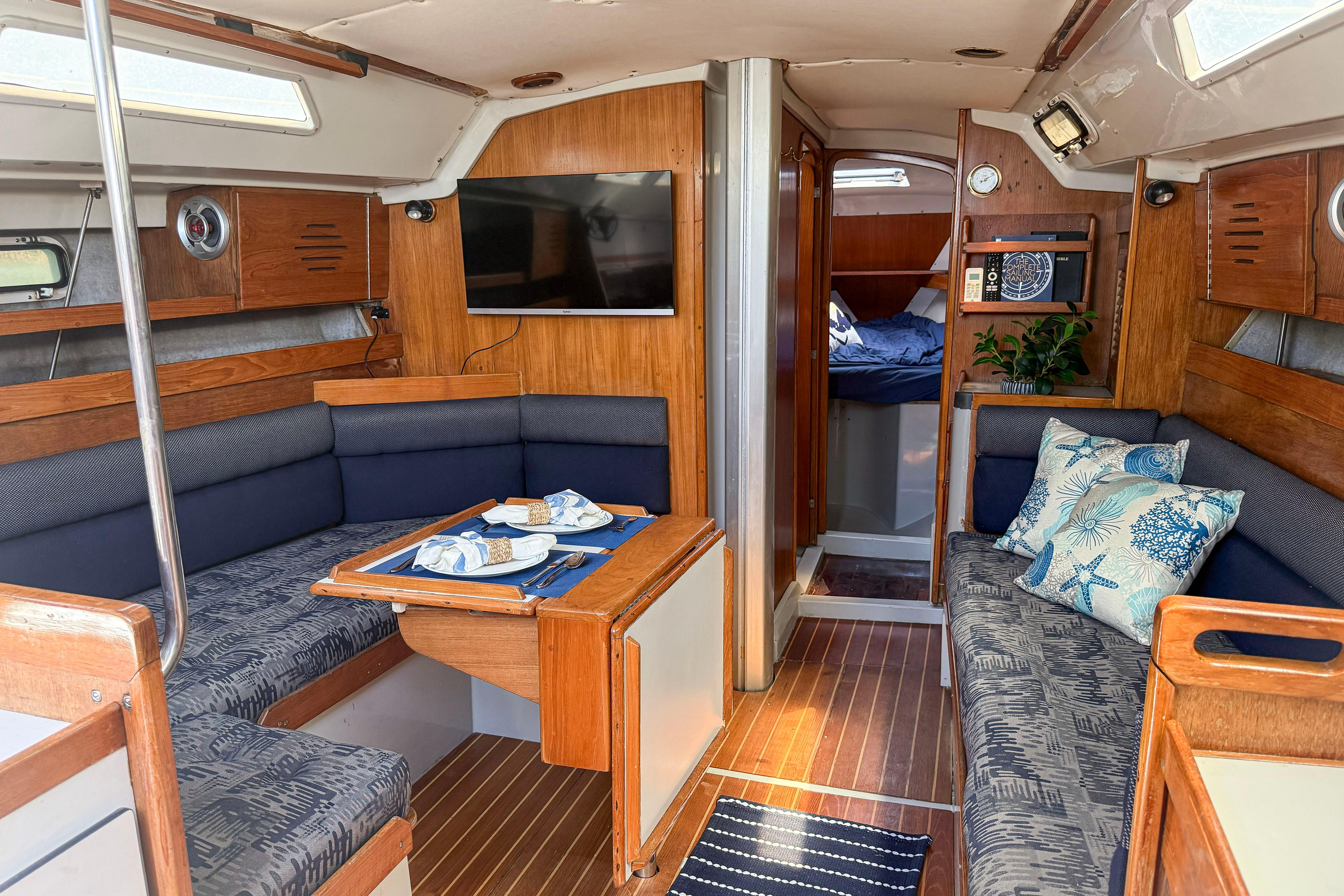 Interior of a 1988 Oday 40 sailboat with cozy seating and nautical decor.