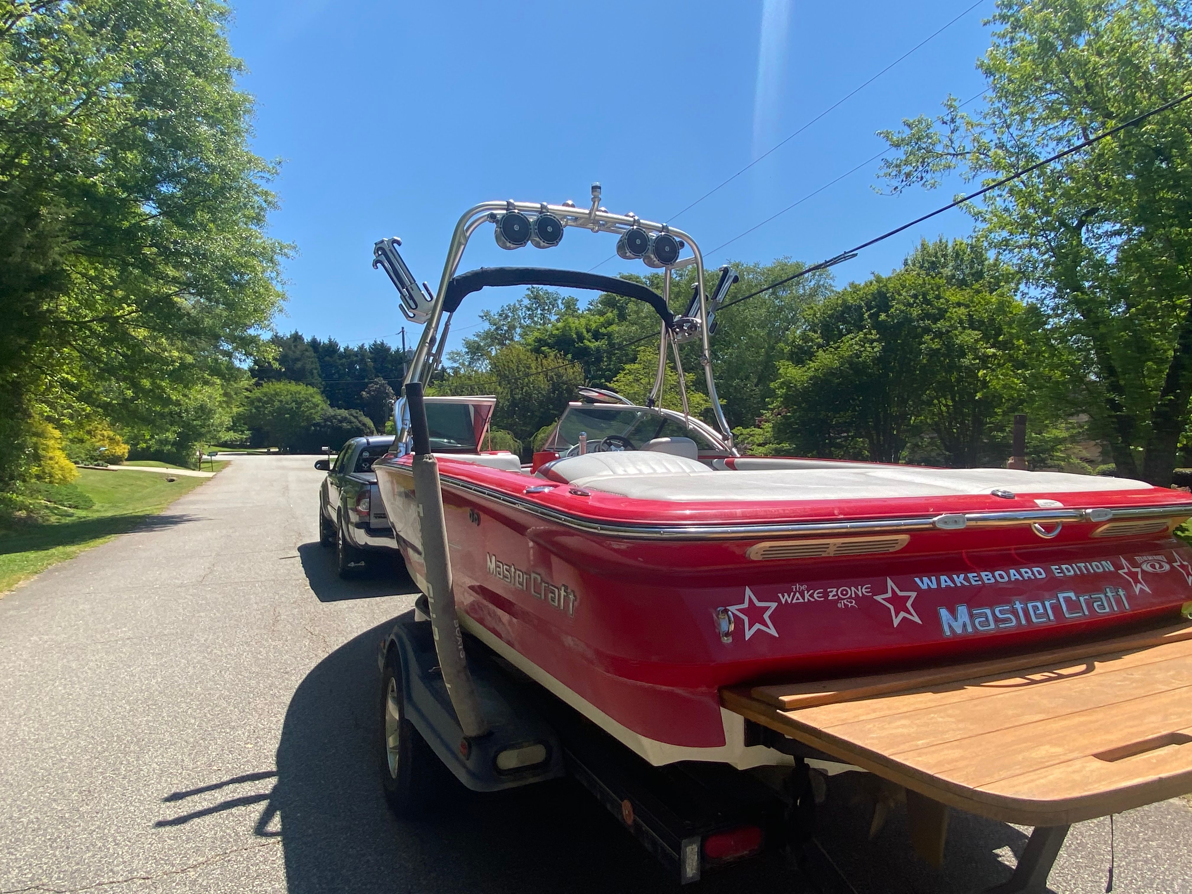 A red 2004 MasterCraft X-9 boat is being transported on a trailer.
