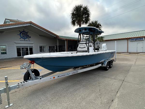 2024 Sea Pro 250 DLX boat on trailer outside dealership, under cloudy sky.