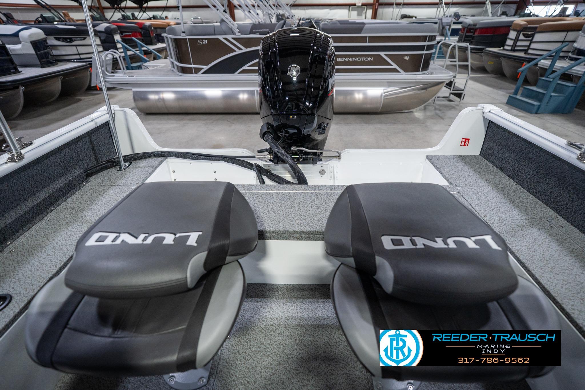 2026 Lund 1700 Explorer Sport boat interior with dual seats and motor in showroom.