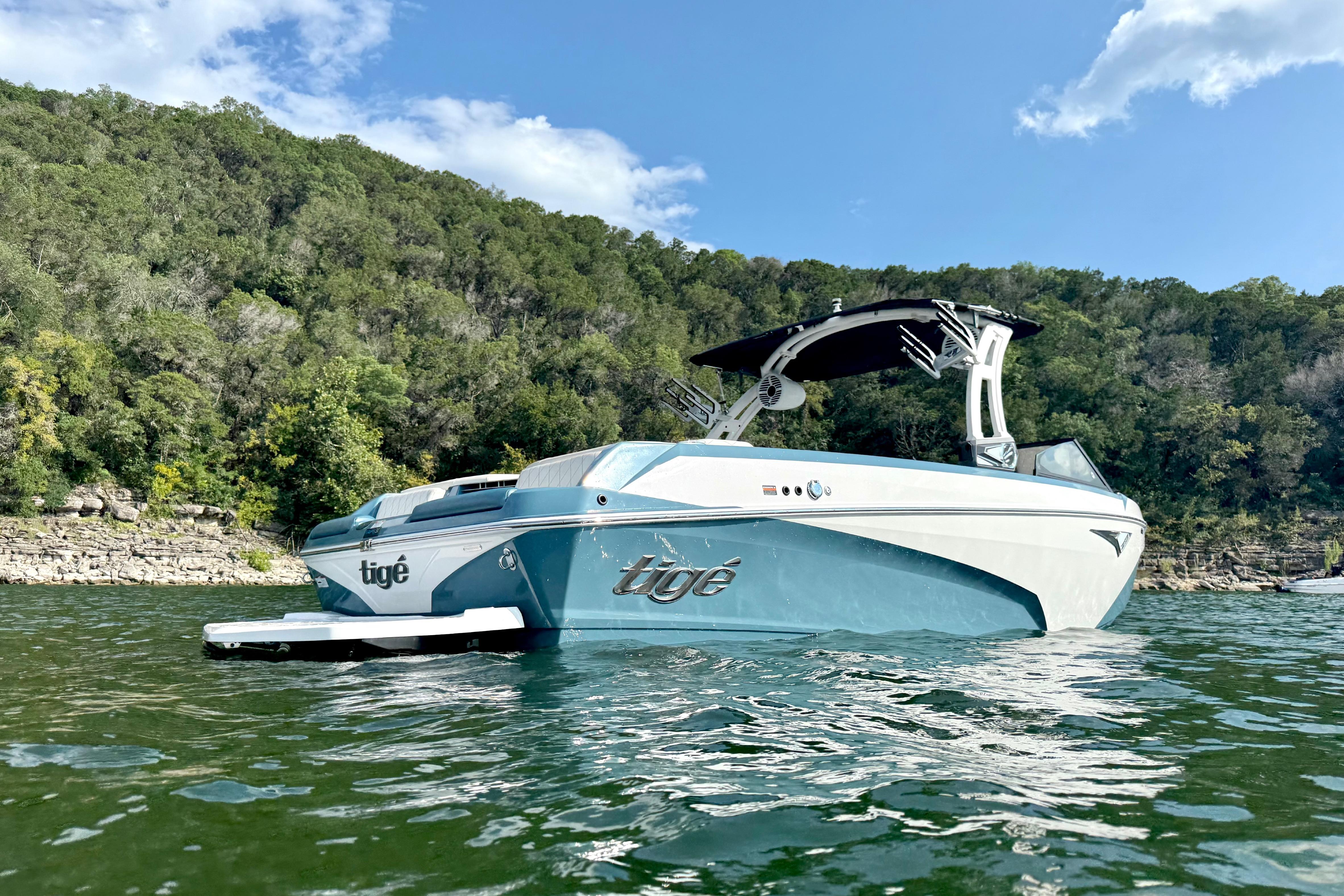 2021 Tige Z3 boat on a scenic lake with lush green hills.