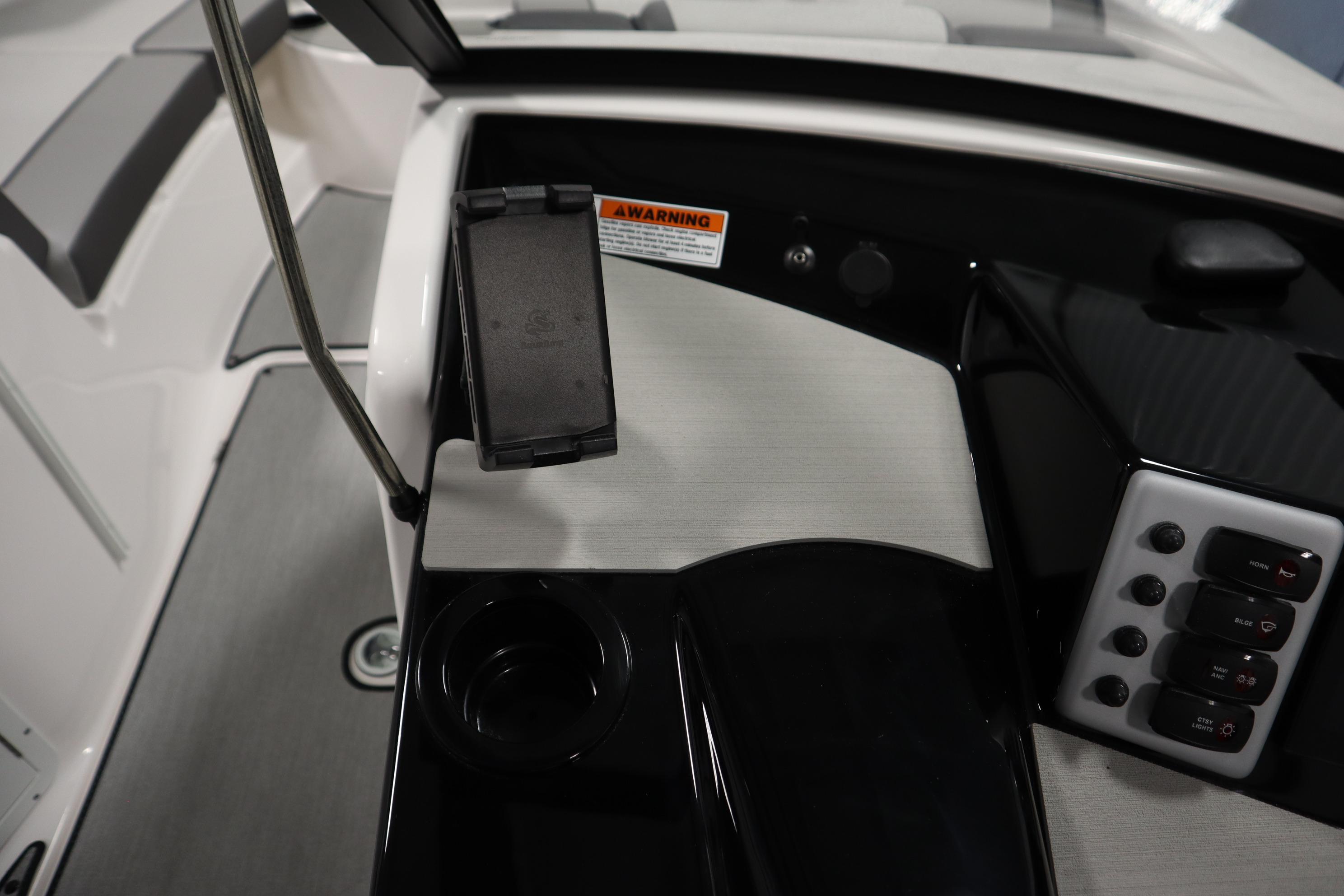 Control panel of 2026 Yamaha Boats AR220, featuring switches and a phone holder.