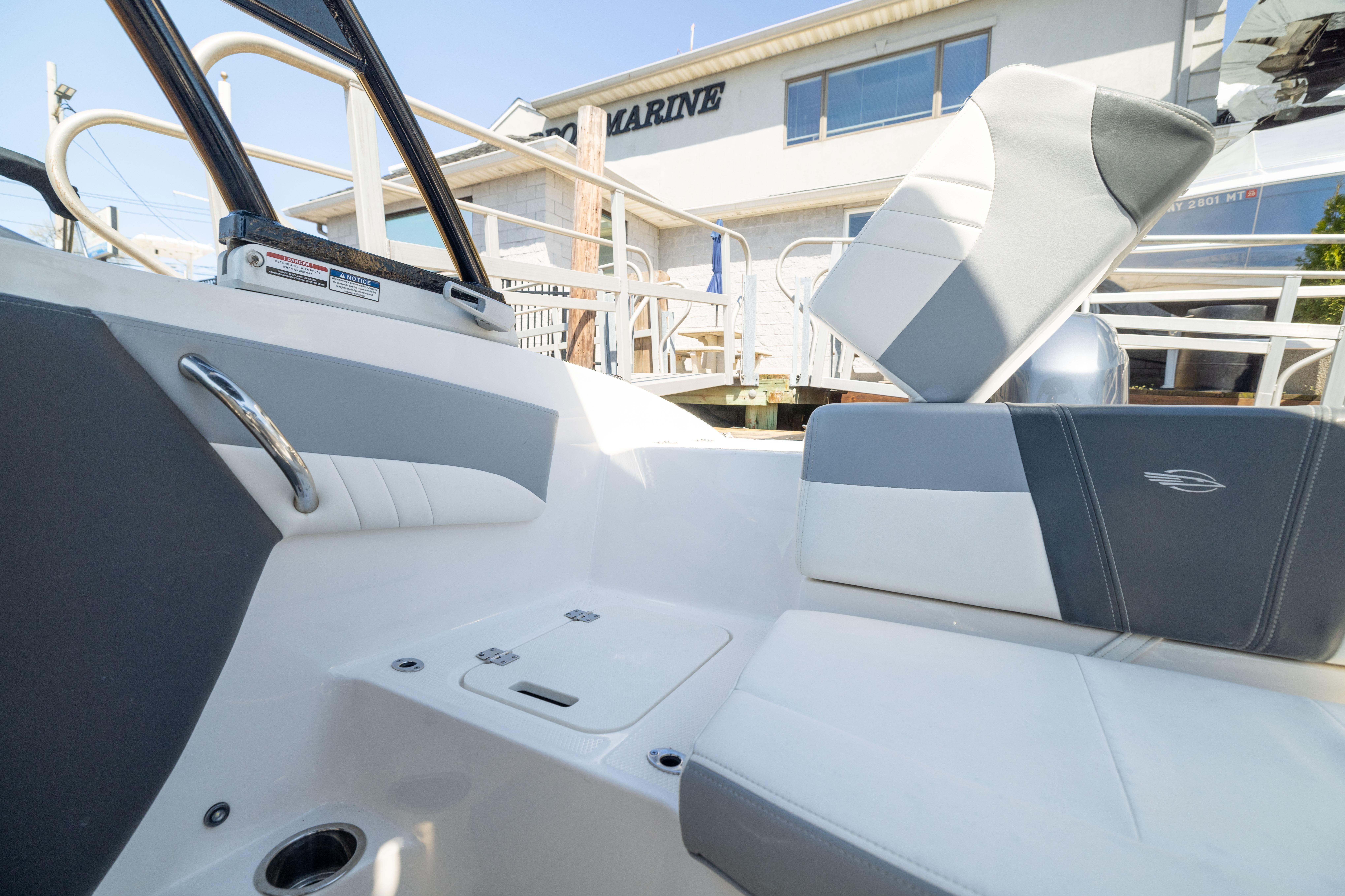 2022 Chaparral 21 SSi OB boat interior with gray and white seating, docked at a marina.