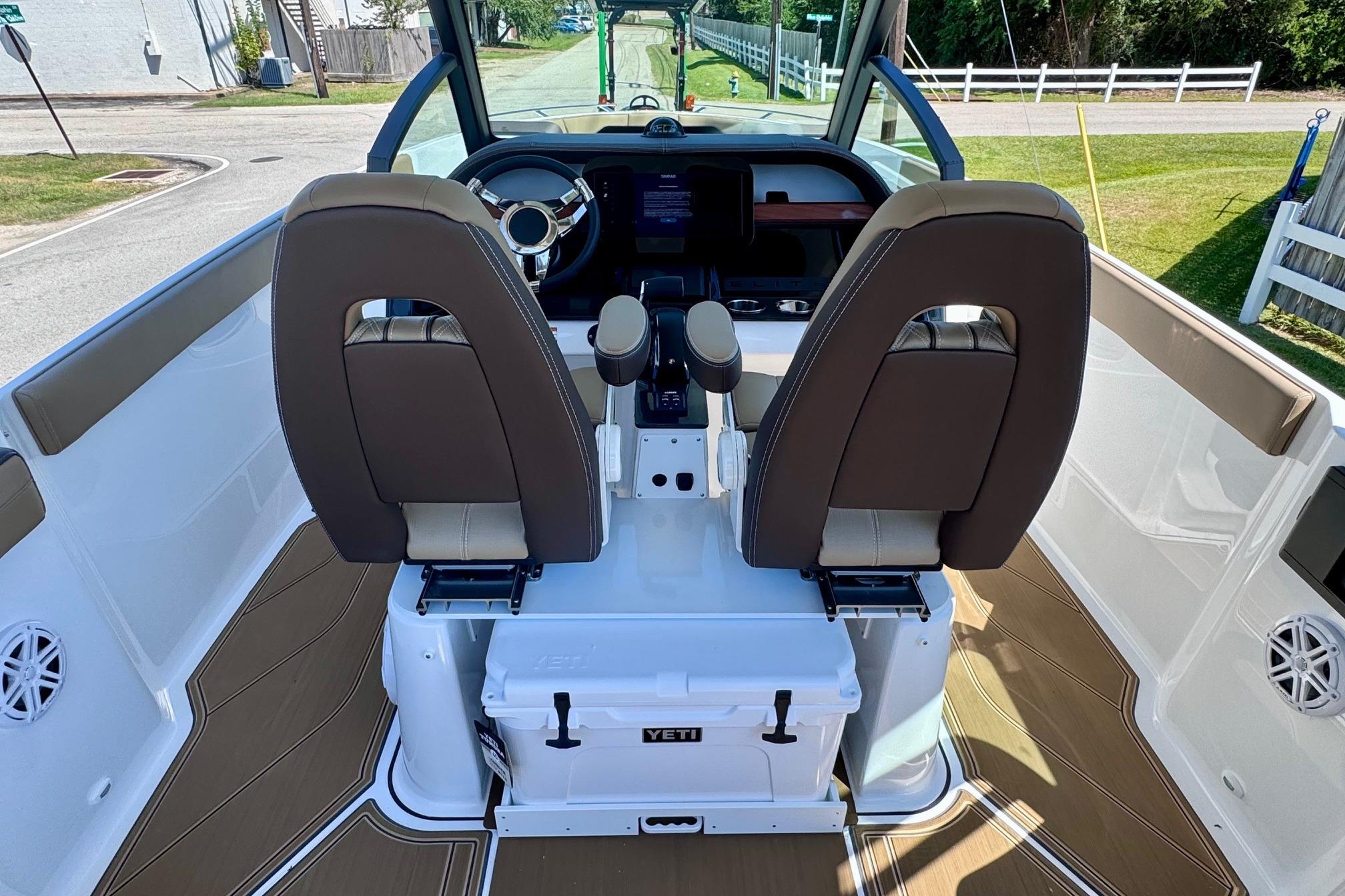 Interior view of 2026 Monterey Elite 27 OB boat cockpit with dual seats and steering wheel.
