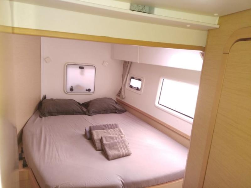 Luxurious cabin interior of 2017 Lagoon 42 catamaran with cozy bed and windows.