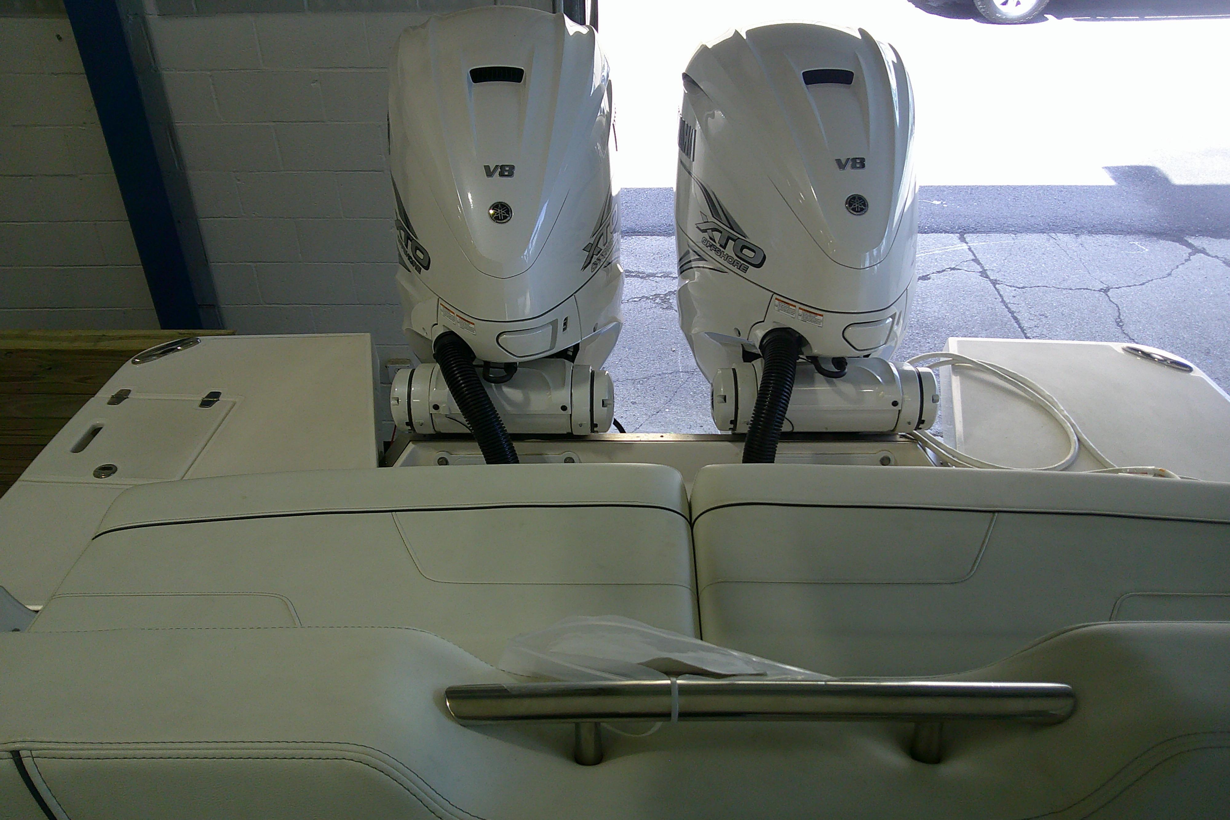 2023 Regal LX36 boat with dual V8 outboard engines in a showroom.
