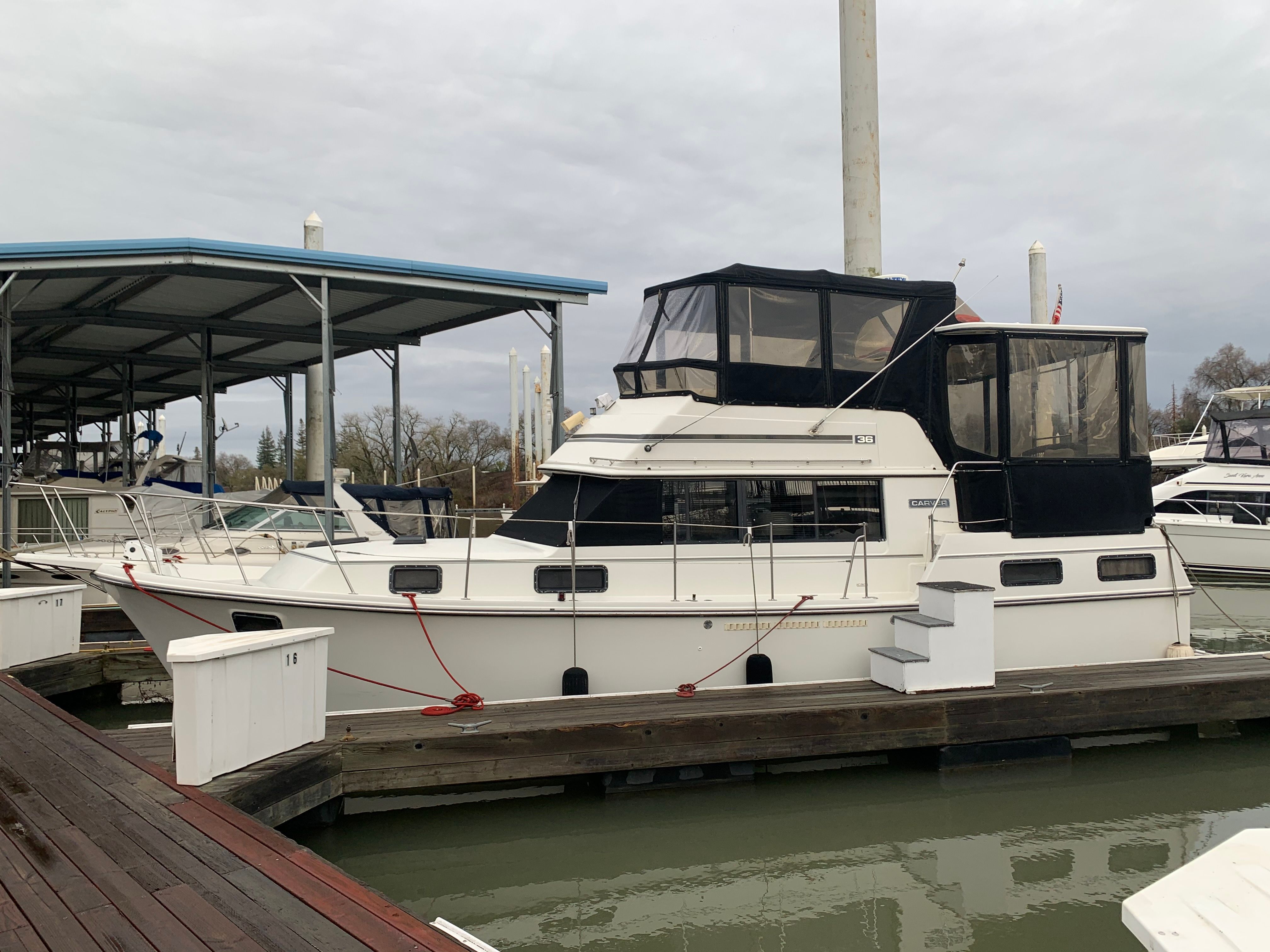 A 1988 Carver 3607 Aft Cabin Motor Yacht docked. It features a covered upper deck.