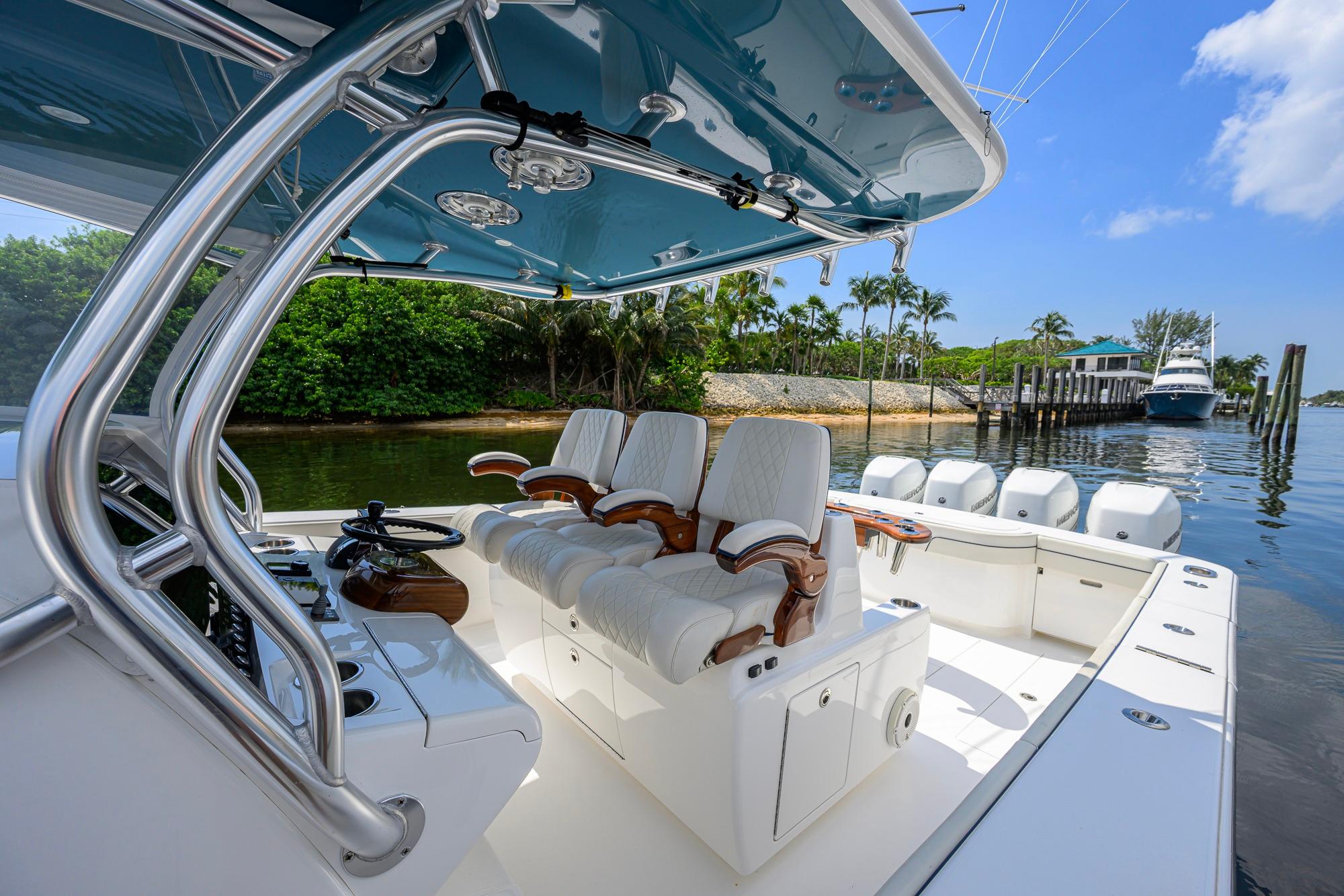 2020 Valhalla Boatworks V-41 with luxurious seating and sleek design docked by lush greenery.