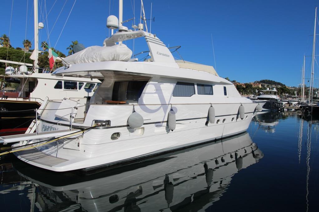 Luxury 1996 Canados 23 yacht docked in a serene marina setting.