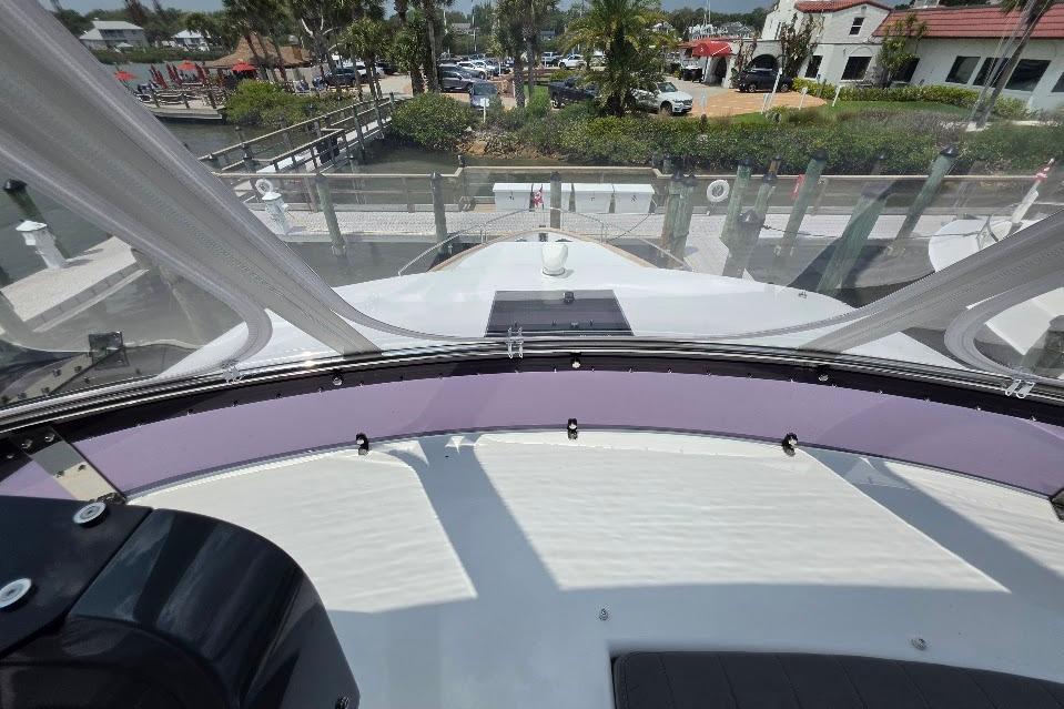 2024 Sirena 58 Flybridge MY yacht helm view with marina backdrop.