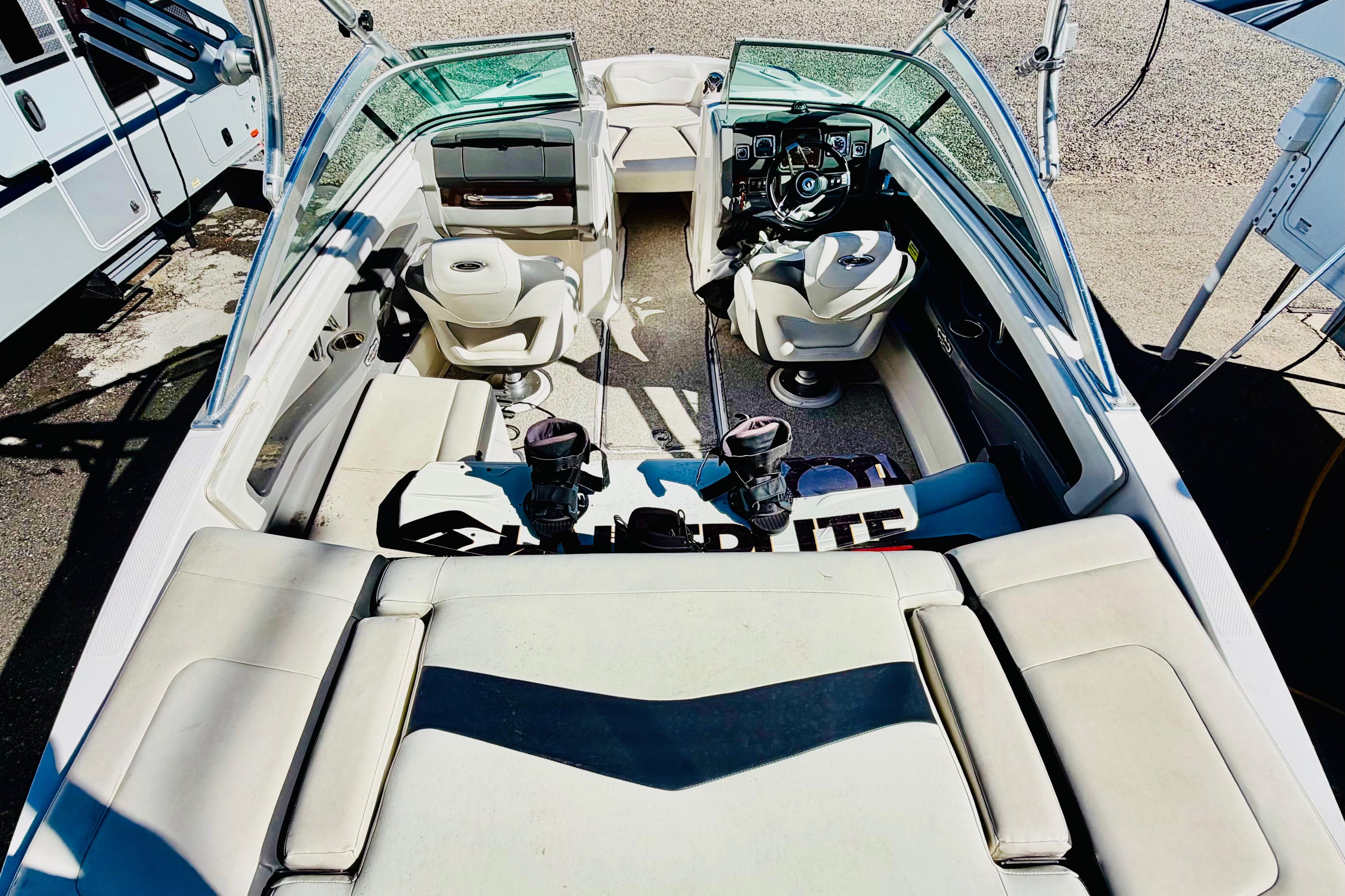 2013 Chaparral 206 SSi boat interior with seating and steering wheel, parked outdoors.