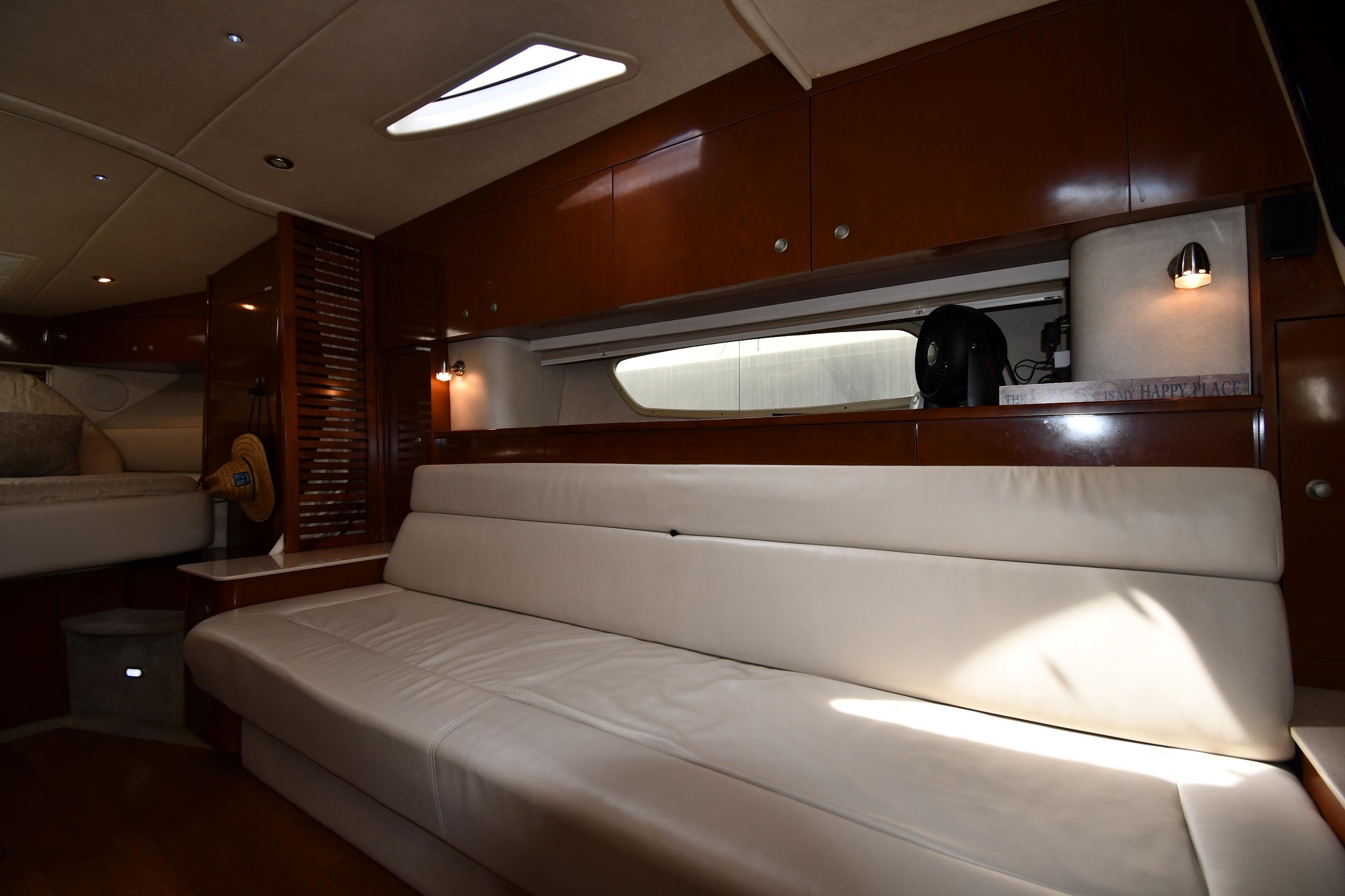 Interior of 2008 Sea Ray Sundancer 350 yacht with white leather seating and wooden cabinetry.
