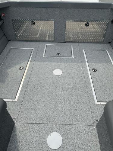 2025 Spartan 200 Astoria boat interior with storage compartments and diamond plate accents.