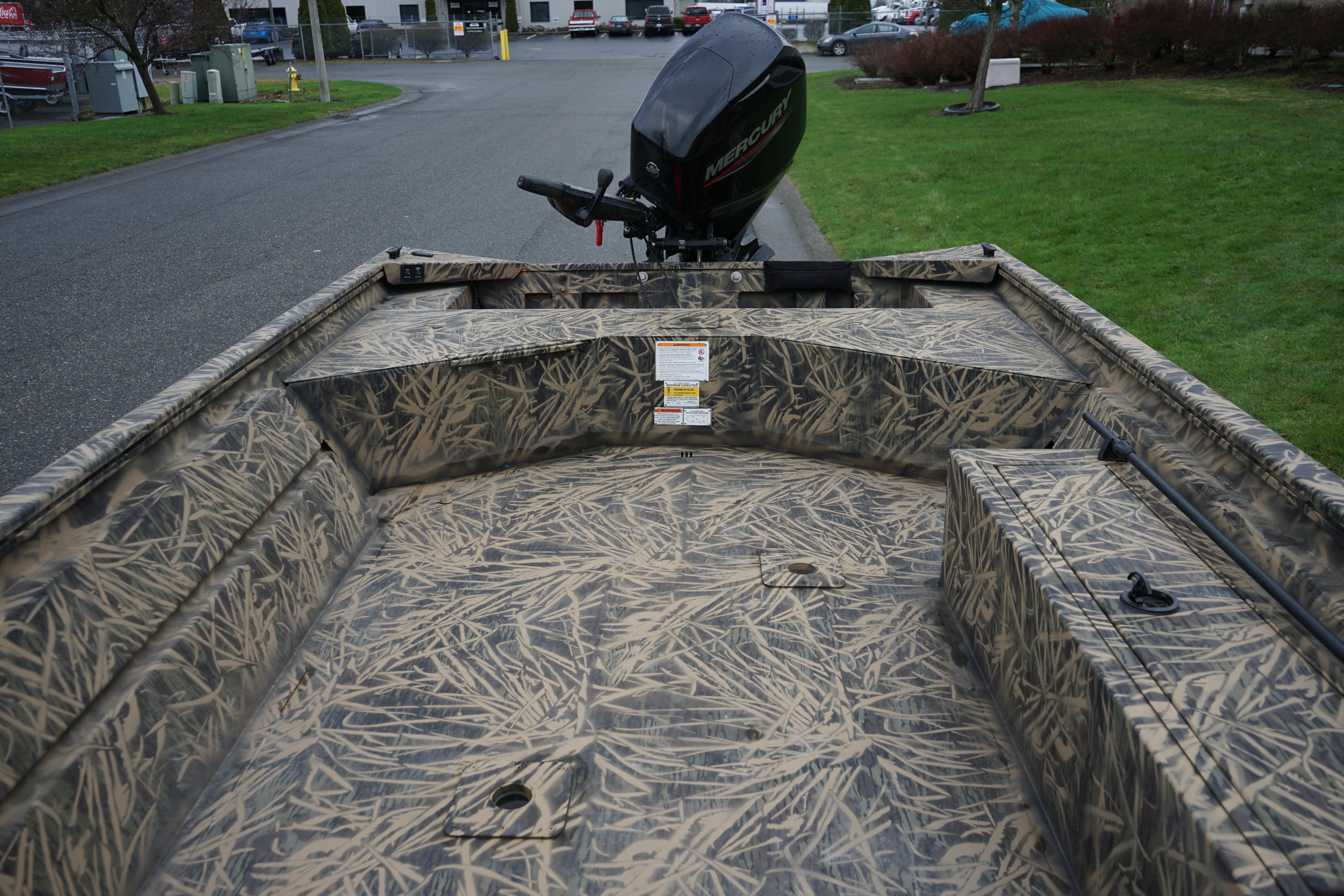 2024 Lund 1760 Predator Tiller boat with camouflage interior and Mercury outboard motor.