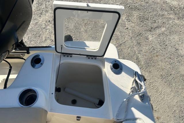 2022 Scout 215 XSF boat with open storage compartment and cup holders.