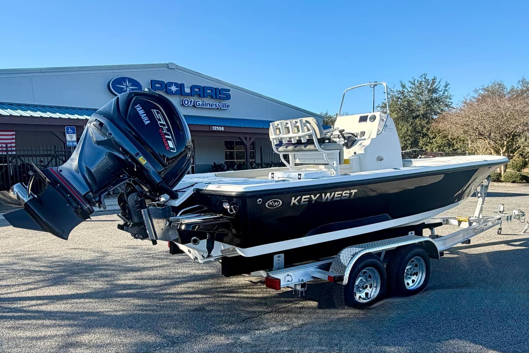 2026 Key West 210 Bay Reef boat on trailer, parked outside dealership.