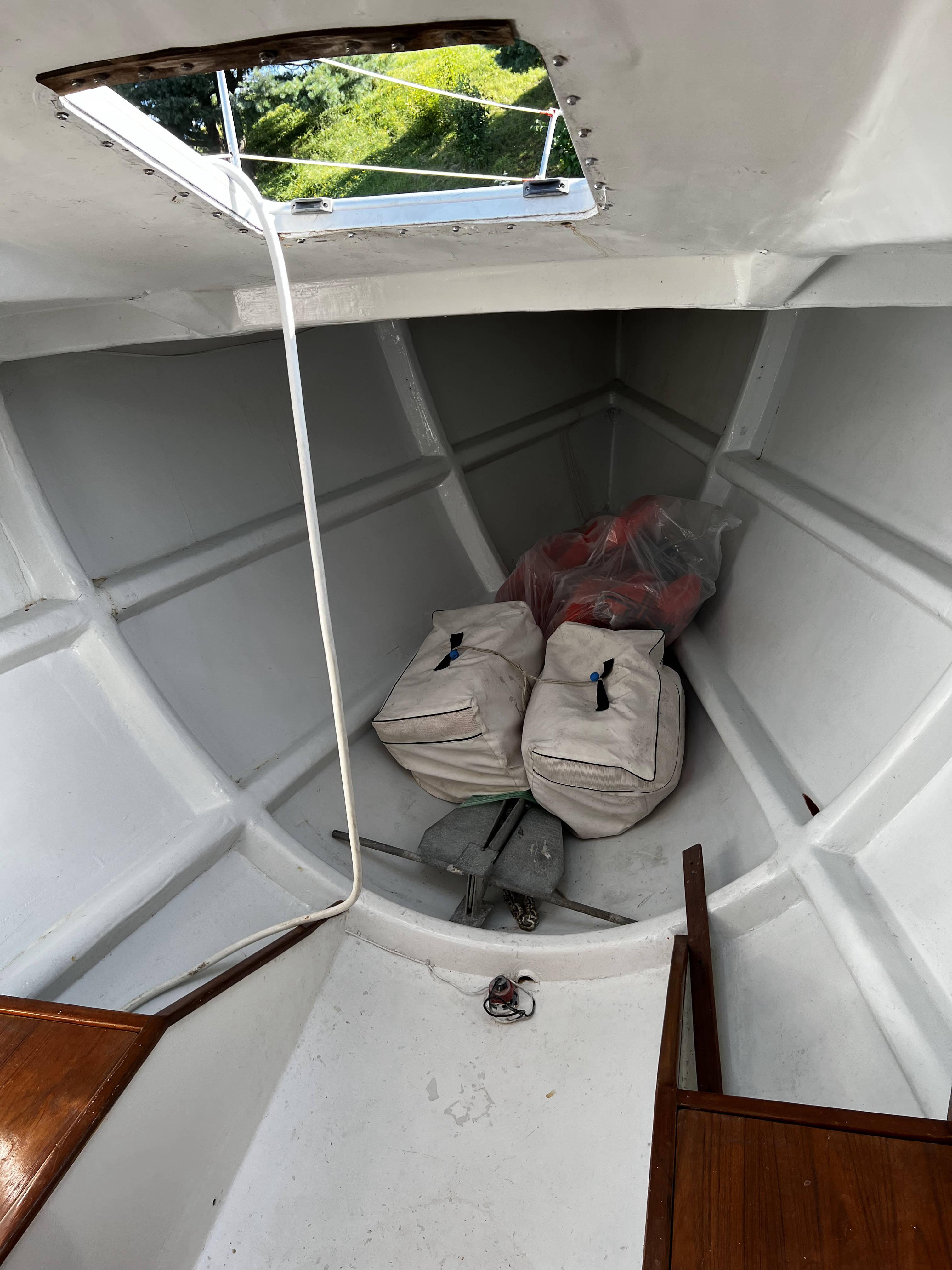 Interior of 1989 Taylor 40 boat with storage bags and open hatch.